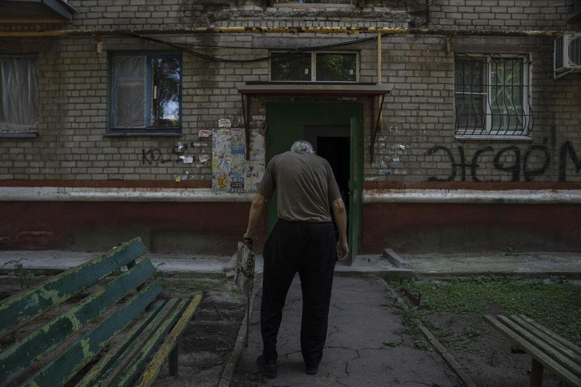 Seventy-year-old pensioner Valerii Ilchenko, who lives alone and is refusing to evacuate, walks to his apartment, after filling out his daily crossword, in Kramatorsk