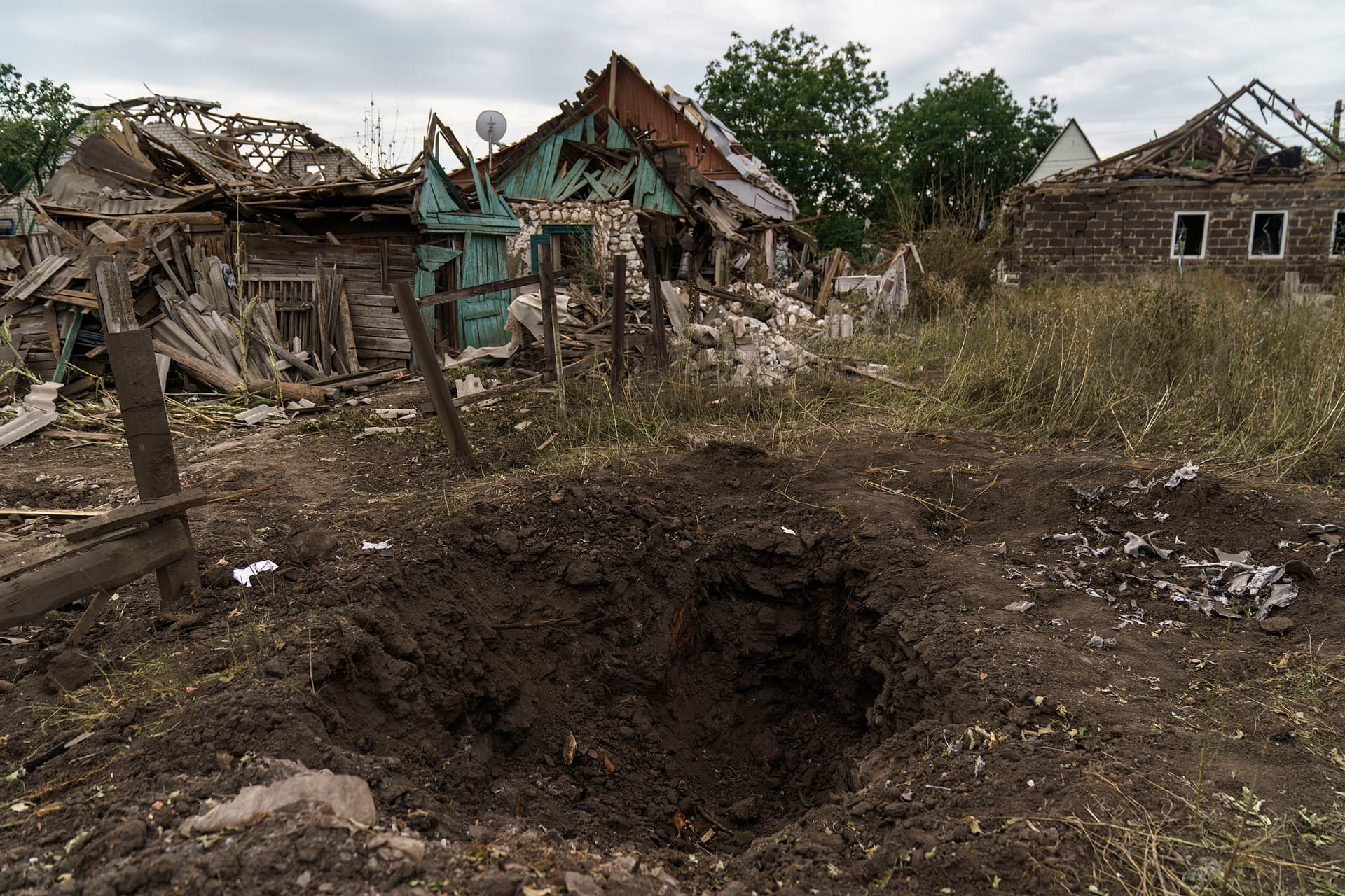 A crater from a Russian rocket attack is seen next to damaged homes in Kramatorsk