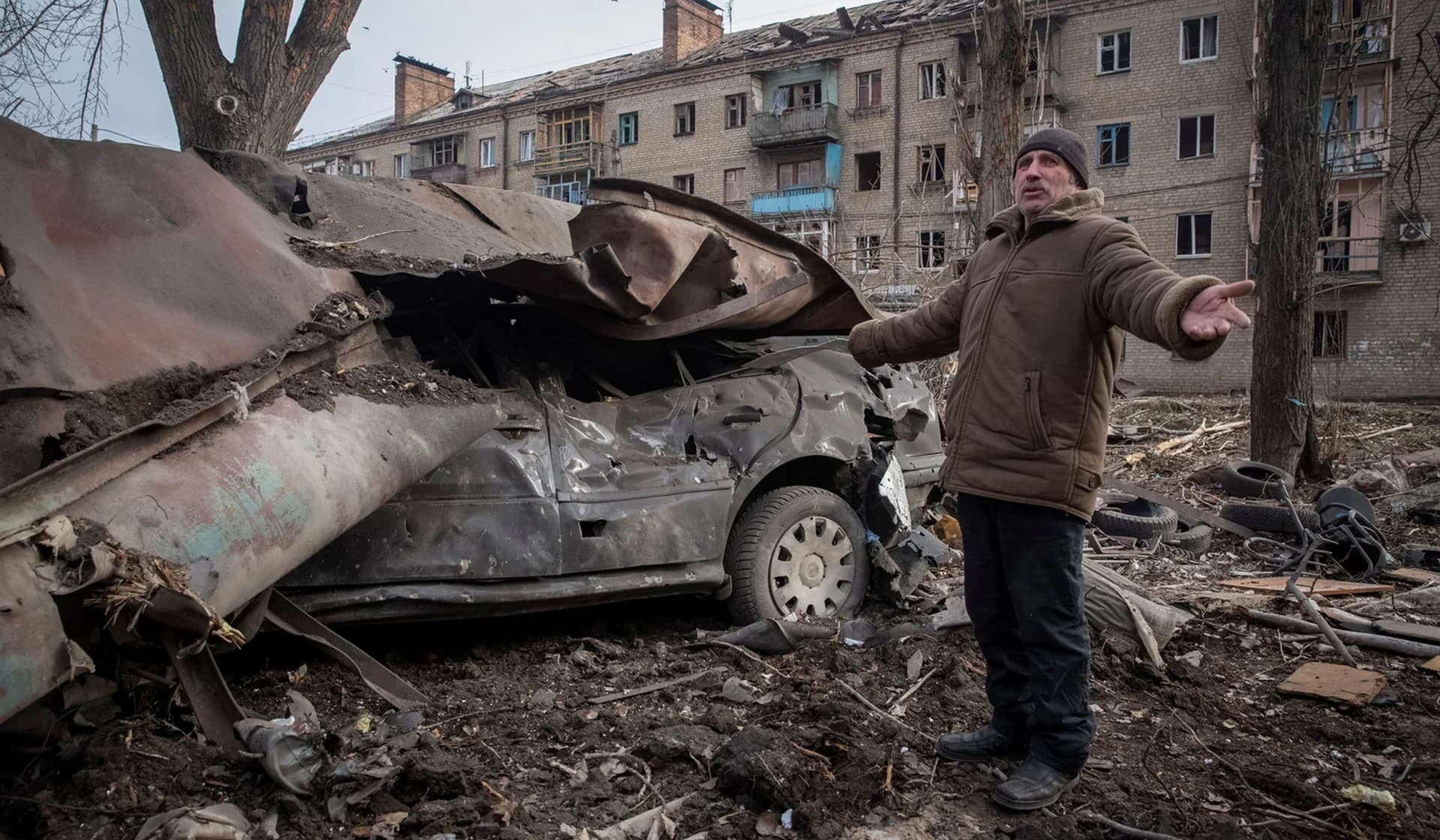 a local resident stands next to his car destroyed by a Russian missile strike in Kostiantynivka