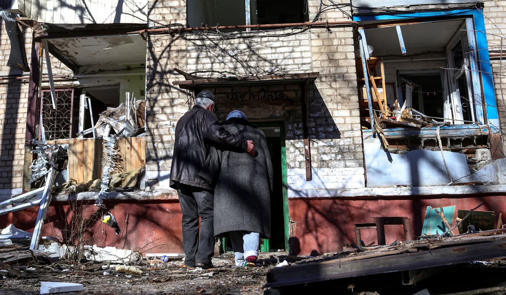 A couple enter a residential building damaged by a Russian missile strike in Kramatorsk