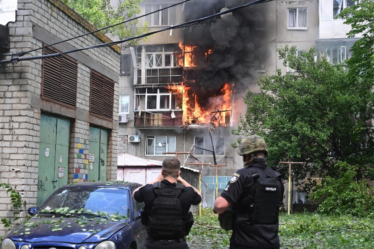 Policemen react in front of a burning building after an air attack hit the courtyard of civilian residences in the centre of Kramatorsk