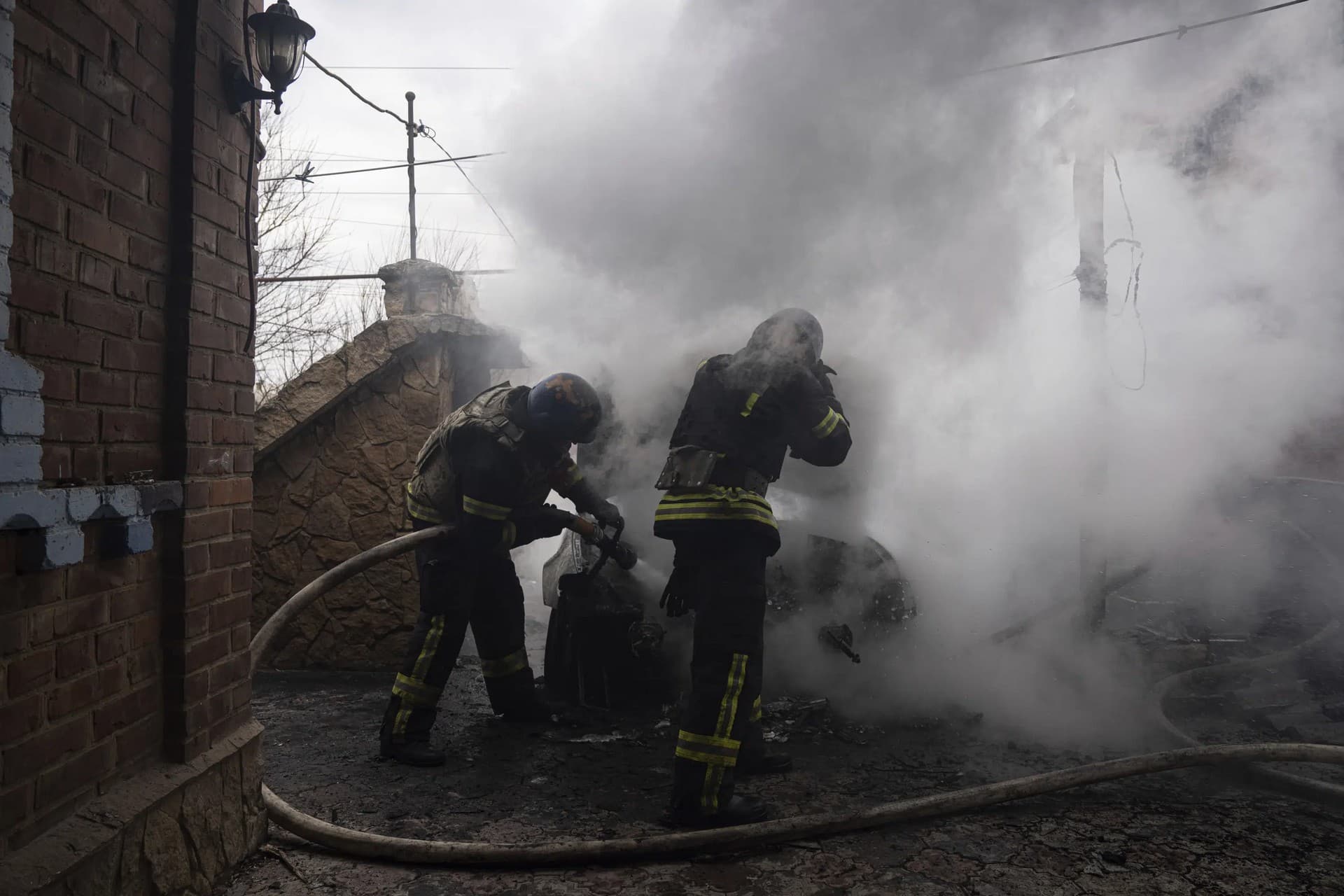 Rescue workers put out the fire of a car which was shelled by Russian forces at the residential neighbourhood in Kostiantynivka
