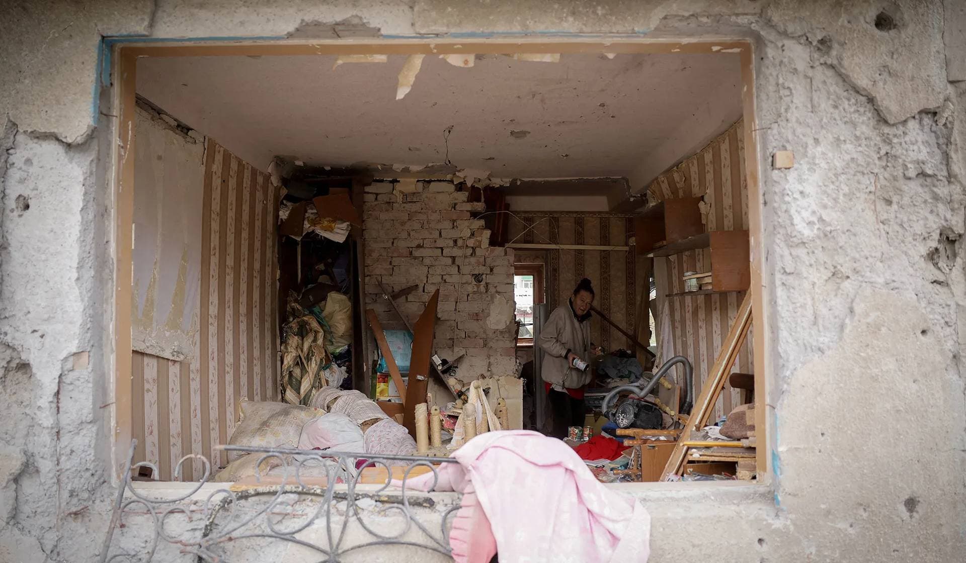 A resident stands in her flat in apartment buildings that were damaged by Russian military strike in the frontline town of Kostiantynivka