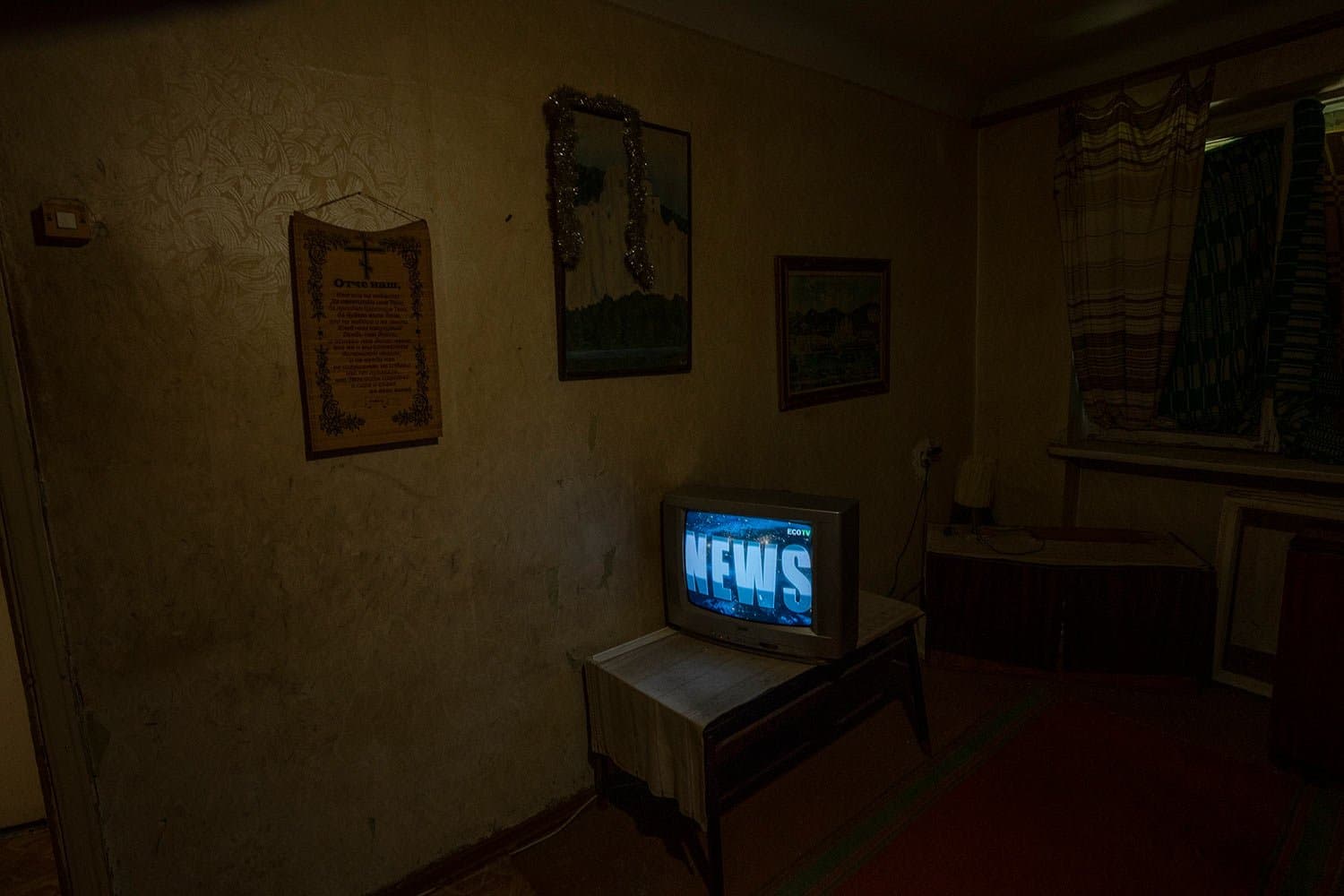 Seventy-year-old pensioner Valerii Ilchenko, who lives alone and is refusing to evacuate, watches the news on his tv in his apartment, in Kramatorsk