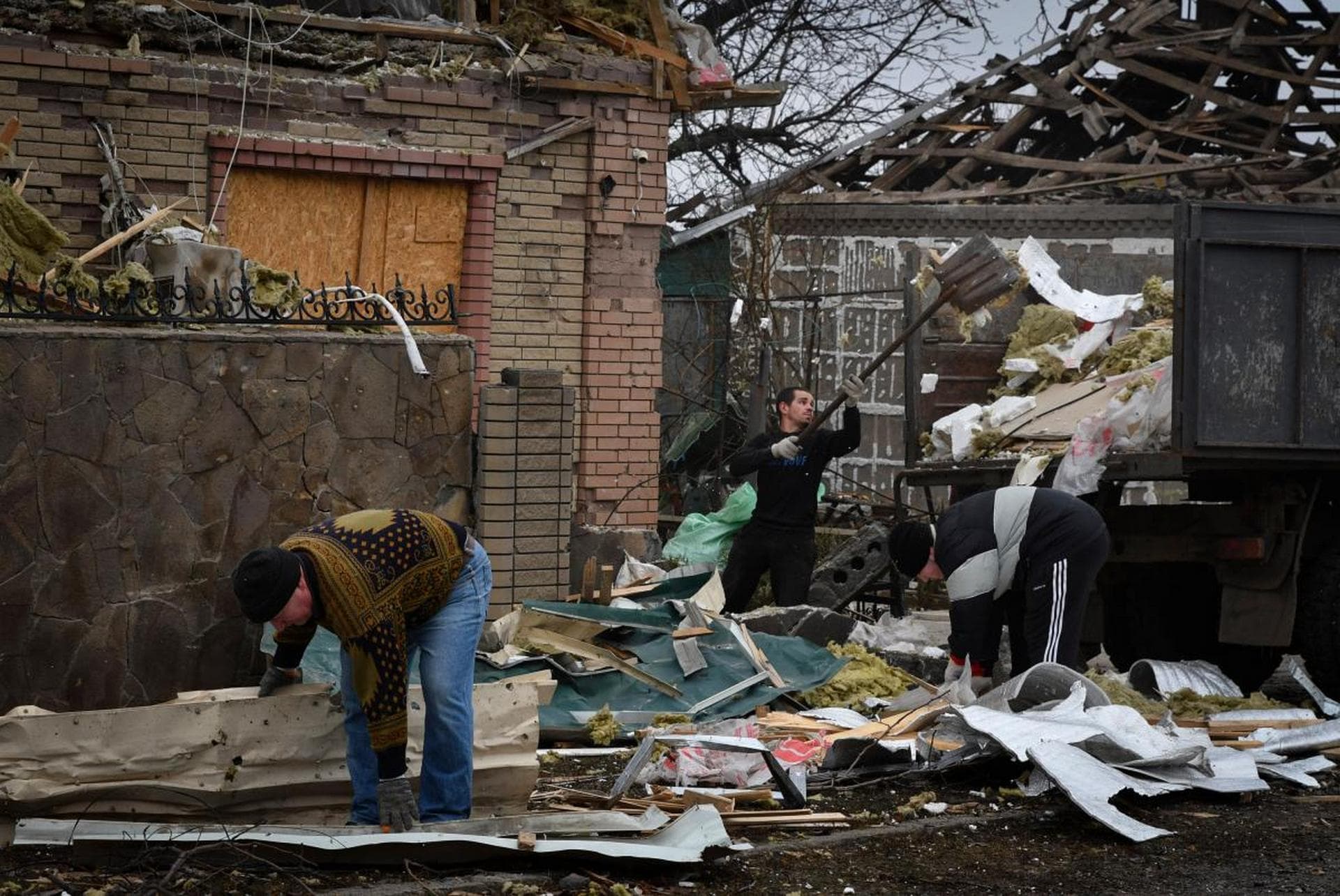 Local residents work to clean the debris from damaged house after Russian shelling in Kramatorsk