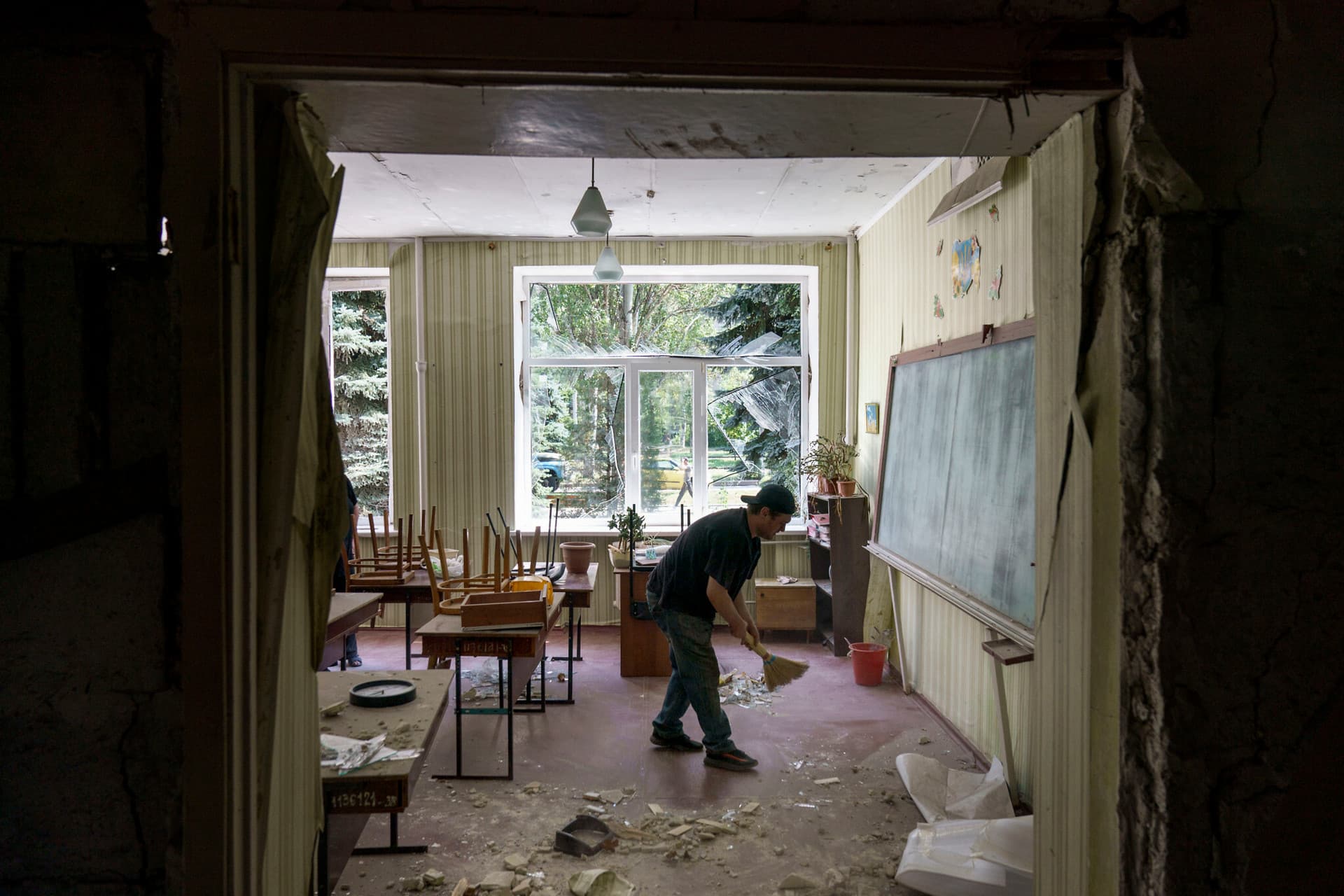 A worker cleans up after an early morning rocket attack hit the Kramatorsk College of Technologies and Design in Kramatorsk