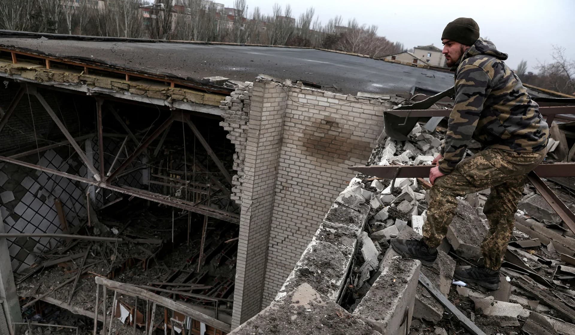 a Ukrainian soldier stands on the roof of a university damaged from a recent missile attack in Kramatorsk
