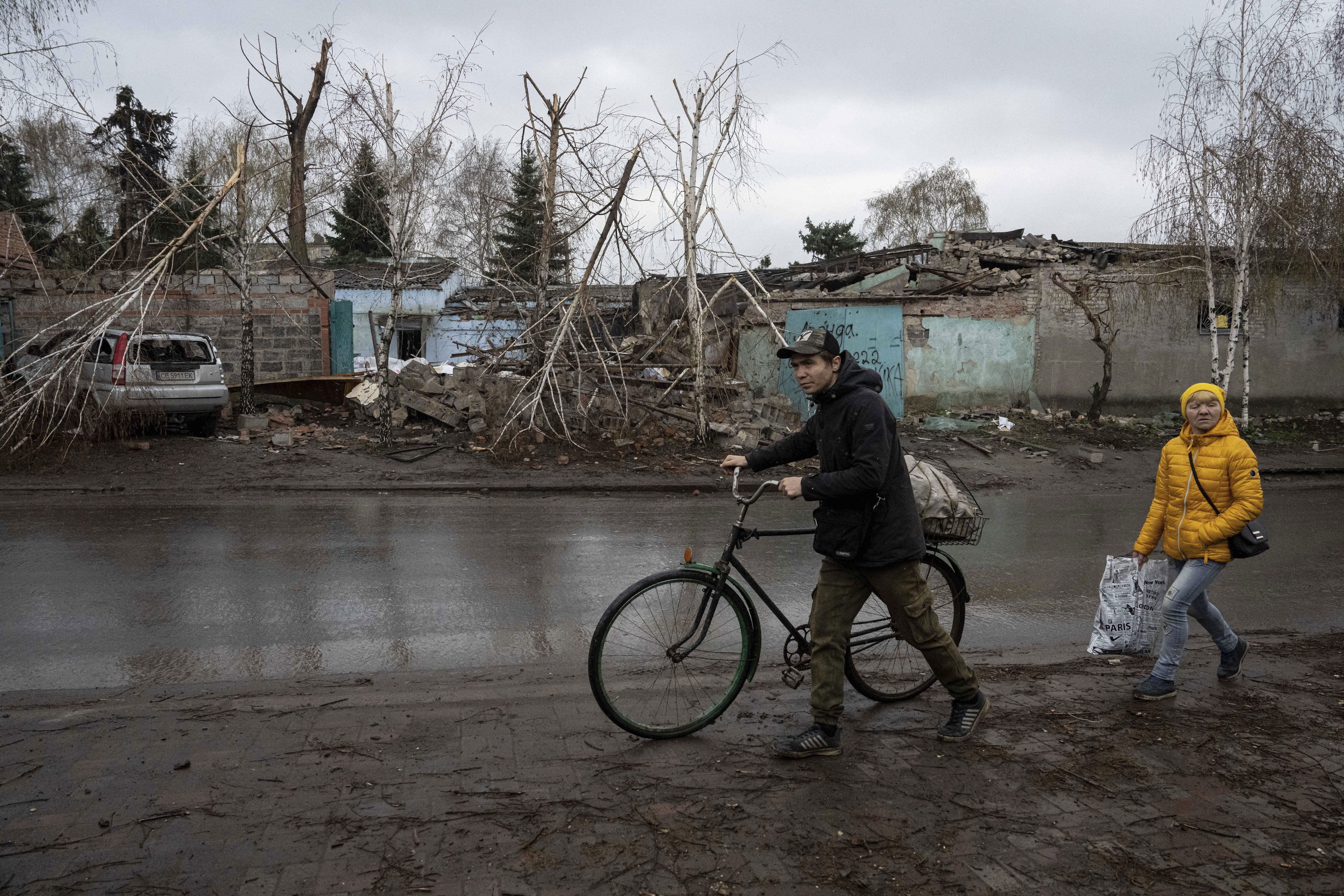 Locals walk past a house which was destroyed by Russian attack in Kostiantynivka