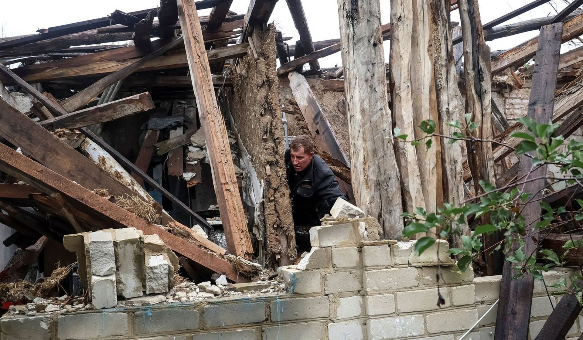 Local resident checks his destroyed house in the village of Dolyna