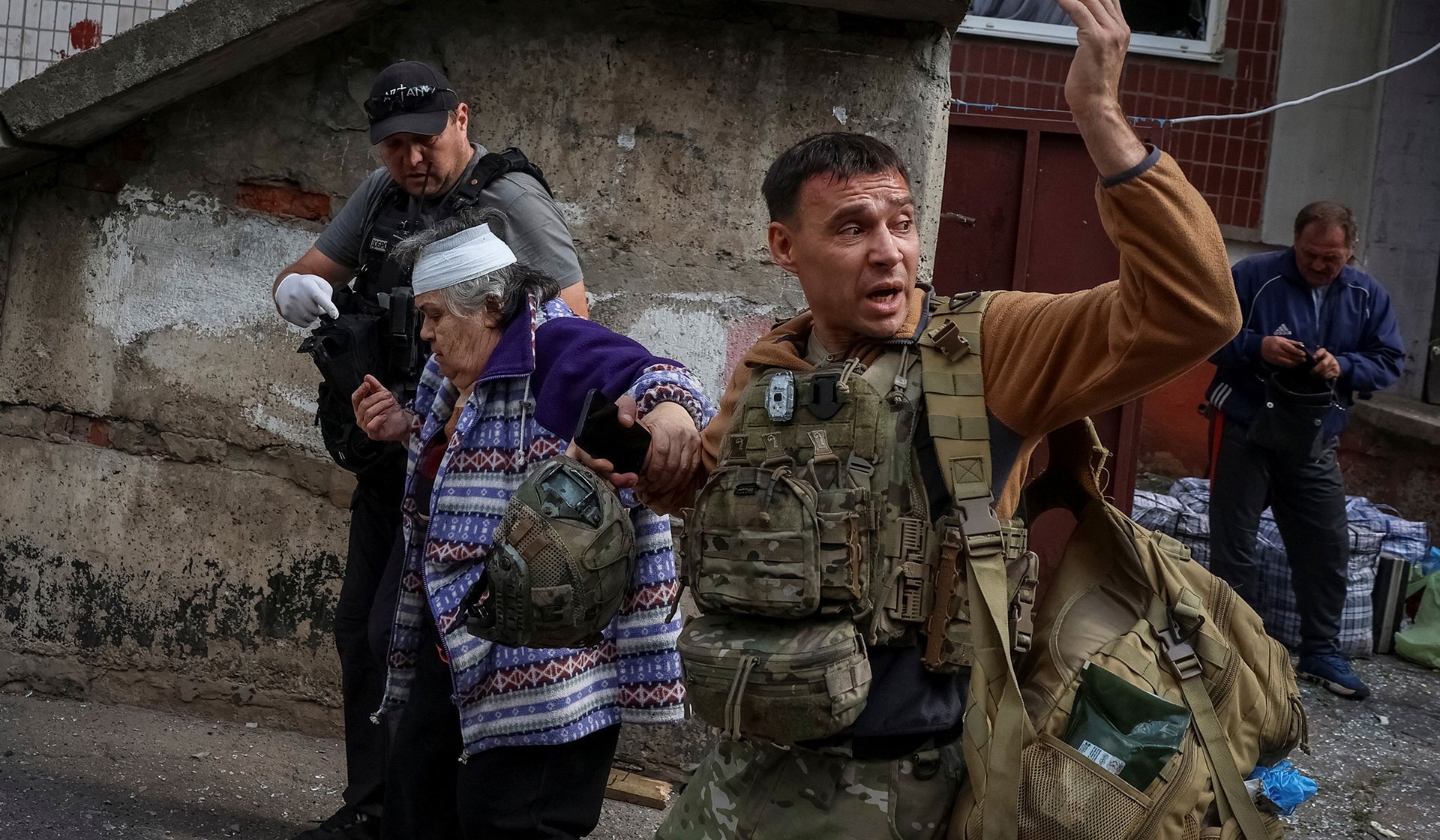 A police officer and a volunteer evacuate a resident  in the frontline city of Kramatorsk