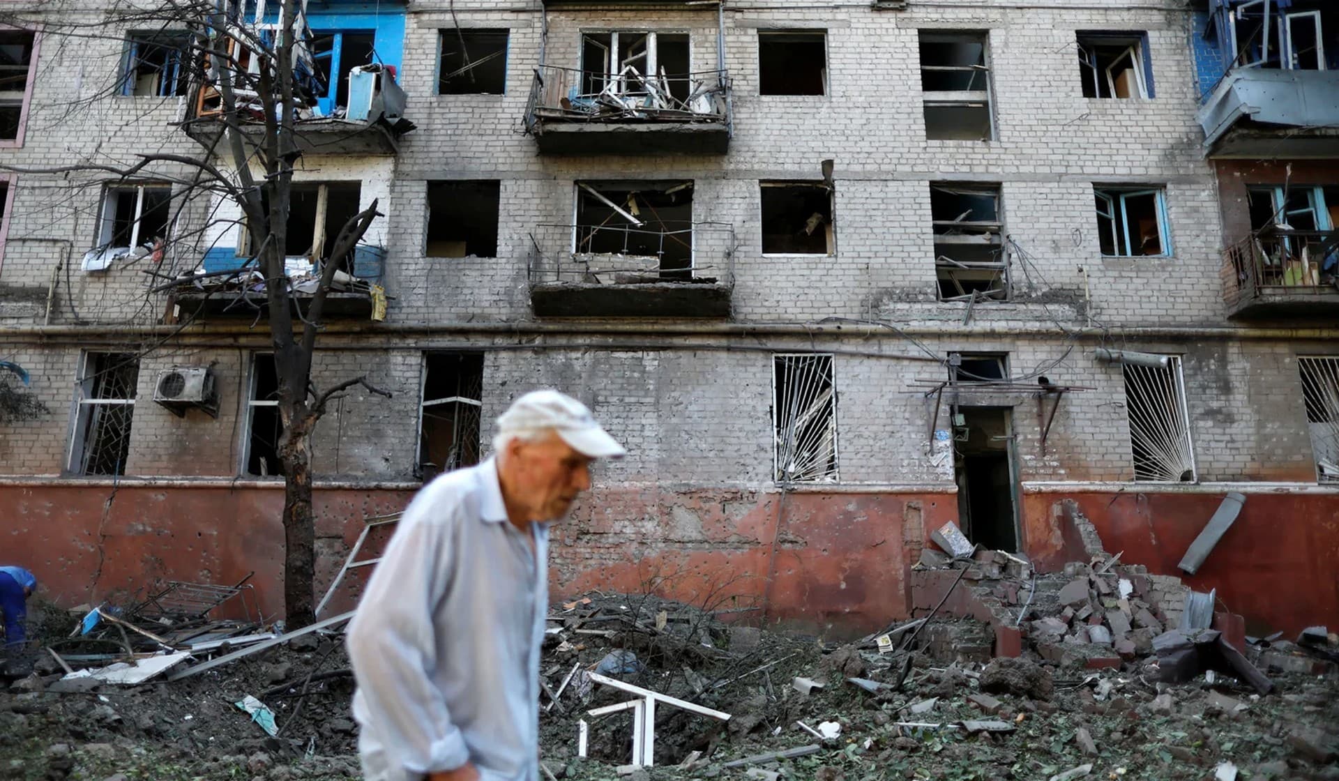 A Ukrainian man walks in front of a residential building damaged after a Russian strike in Kramatorsk