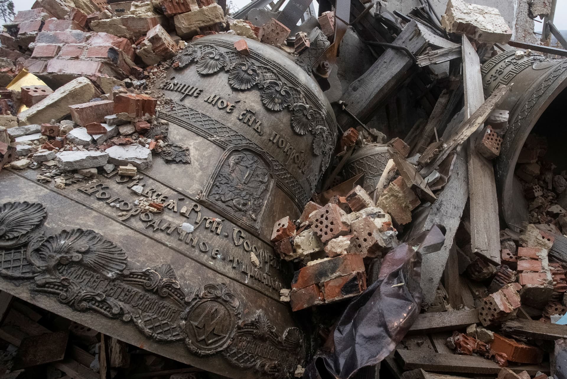 Bells surrounded by debris of a destroyed Orthodox church in the village of Bohorodychne