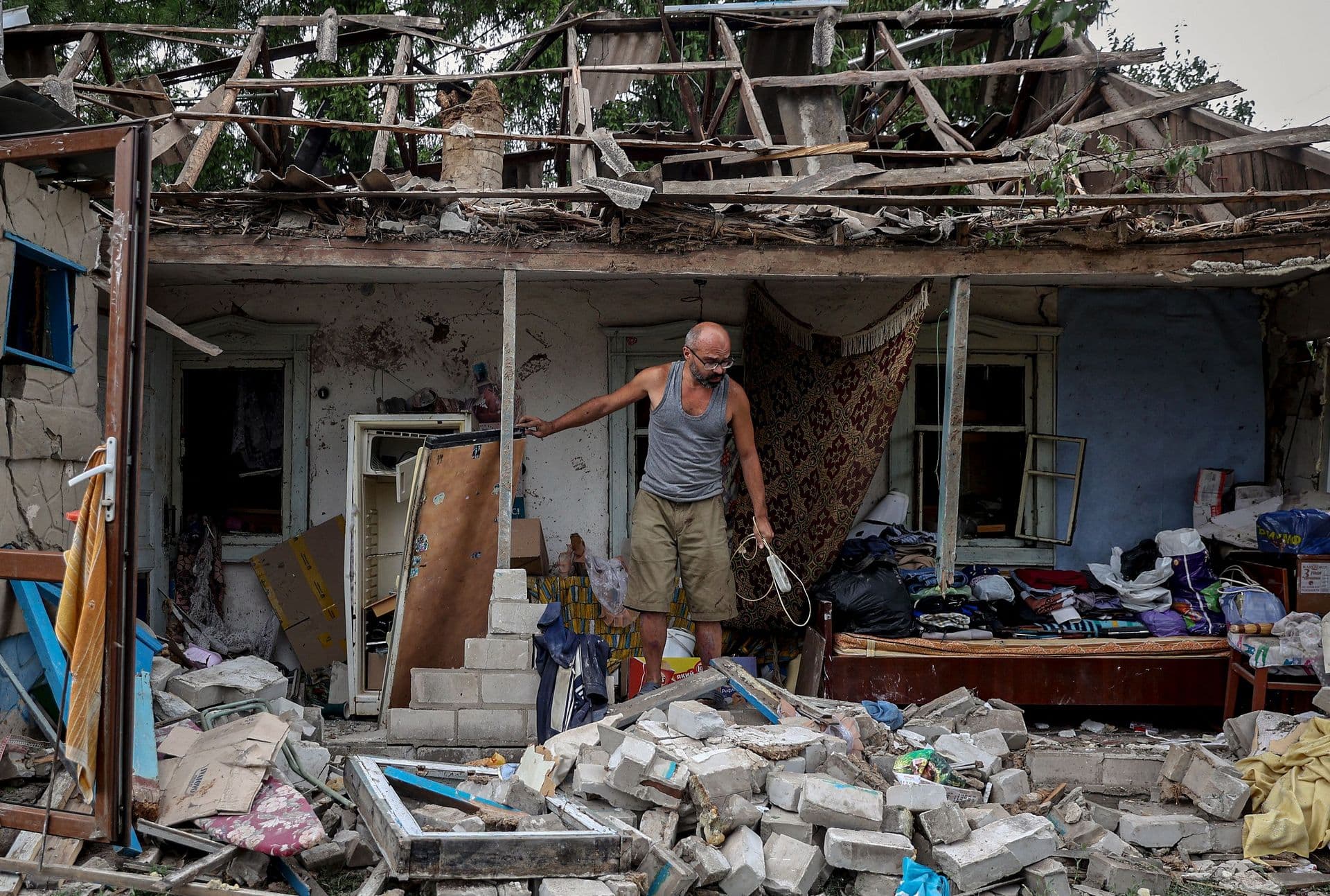 A man collects belongings from his destroyed house after a missile attack in the town of Kramatorsk