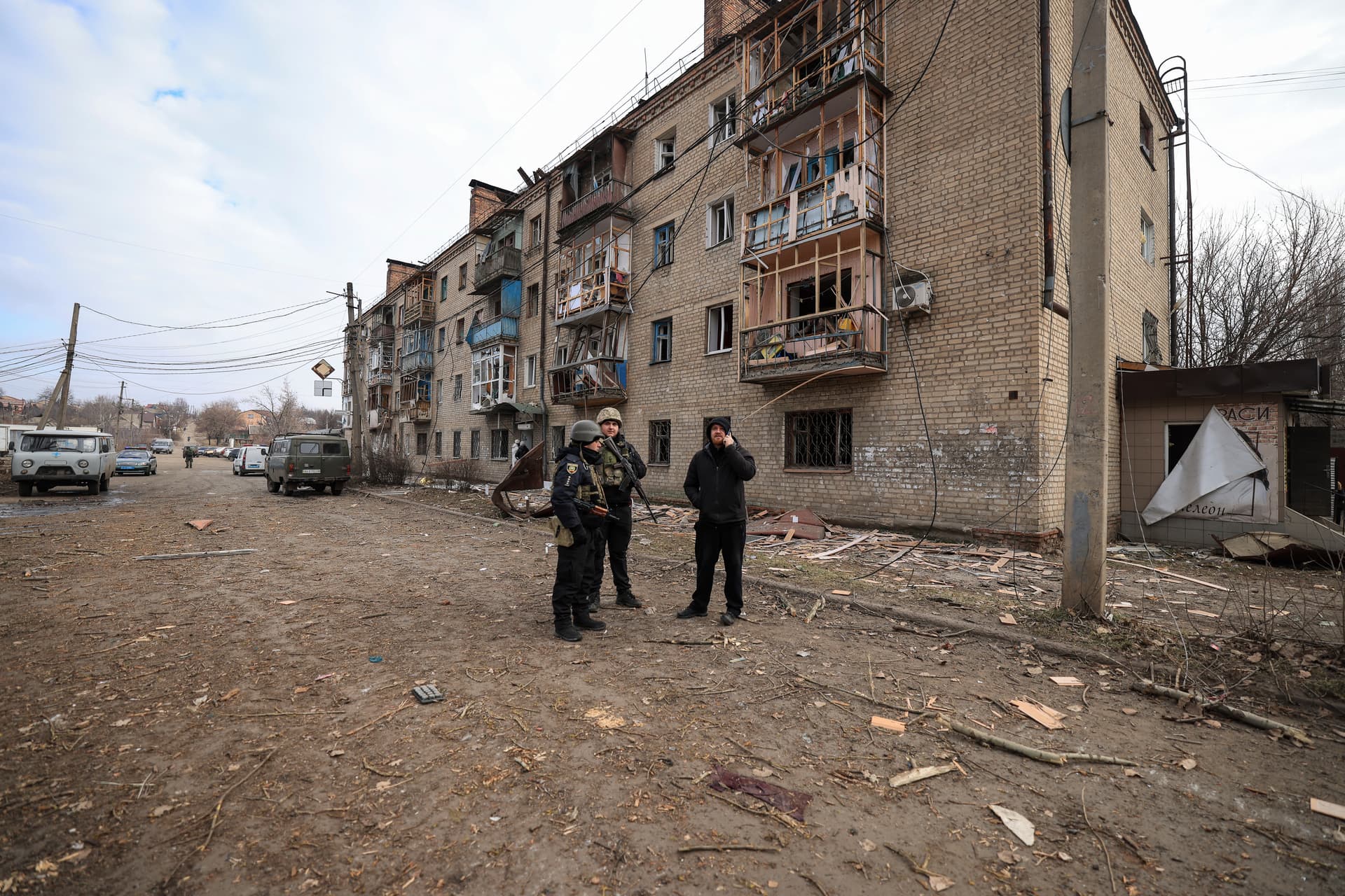 Ukrainian police officers stand in front of a house which was damaged after a Russian attack in Kostiantynivka
