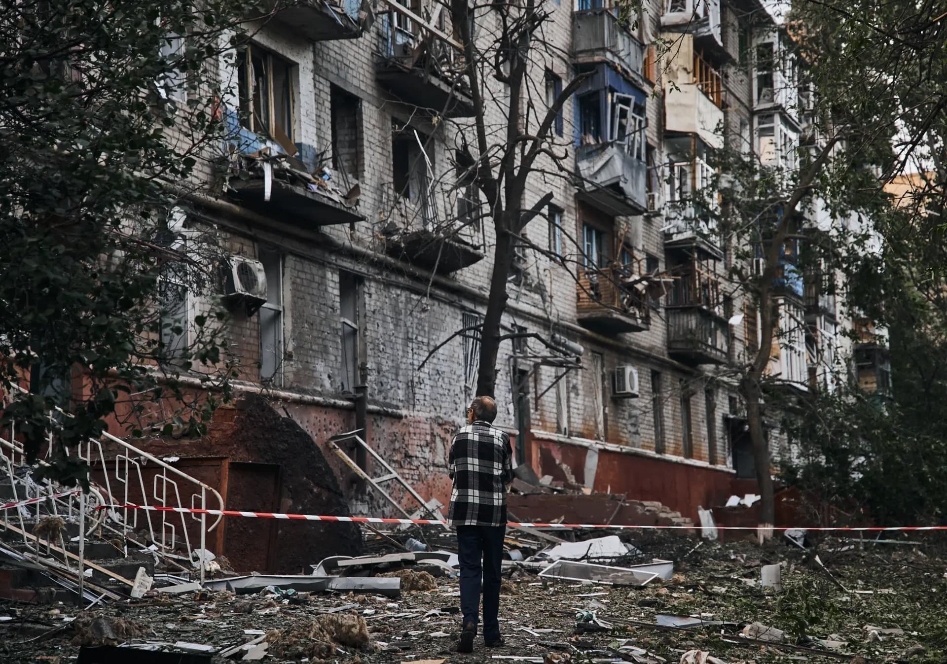 A resident looks at a damaged building after a rocket attack early Wednesday morning, in Kramatorsk