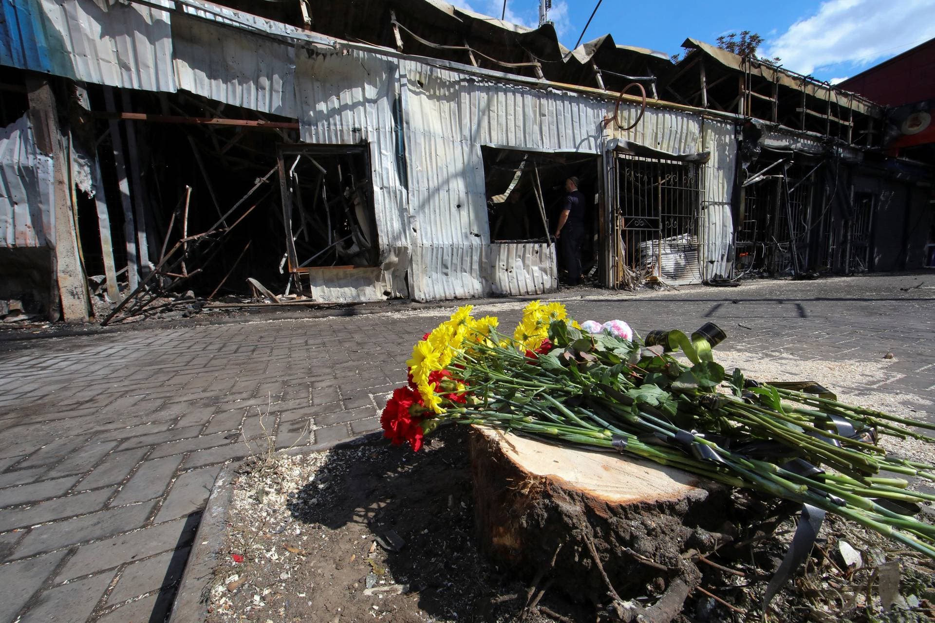 Flowers left by local residents to pay tribute to civilian people killed yesterday are seen at the strike site in Kostiantynivka