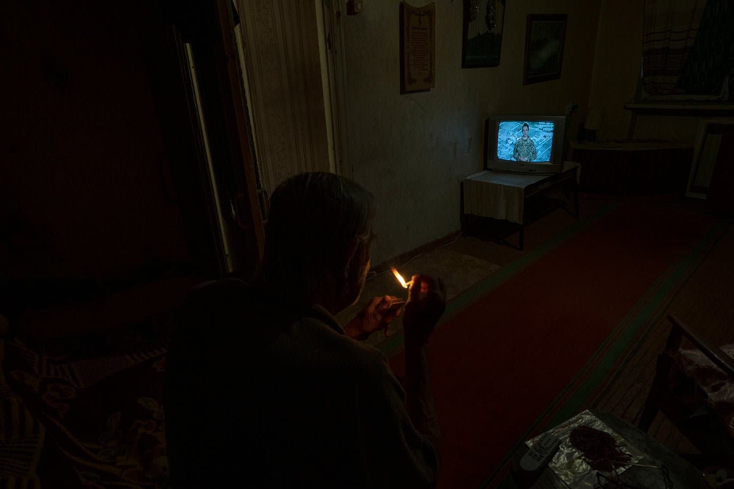 Seventy-year-old pensioner Valerii Ilchenko, who lives alone and is refusing to evacuate, watches television in his apartment, in Kramatorsk