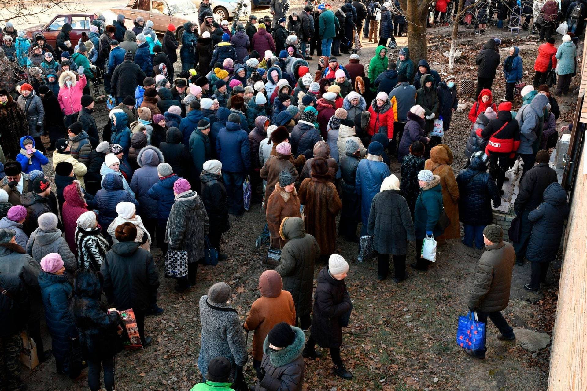 People wait to receive food at a humanitarian aid distribution spot in Kramatorsk