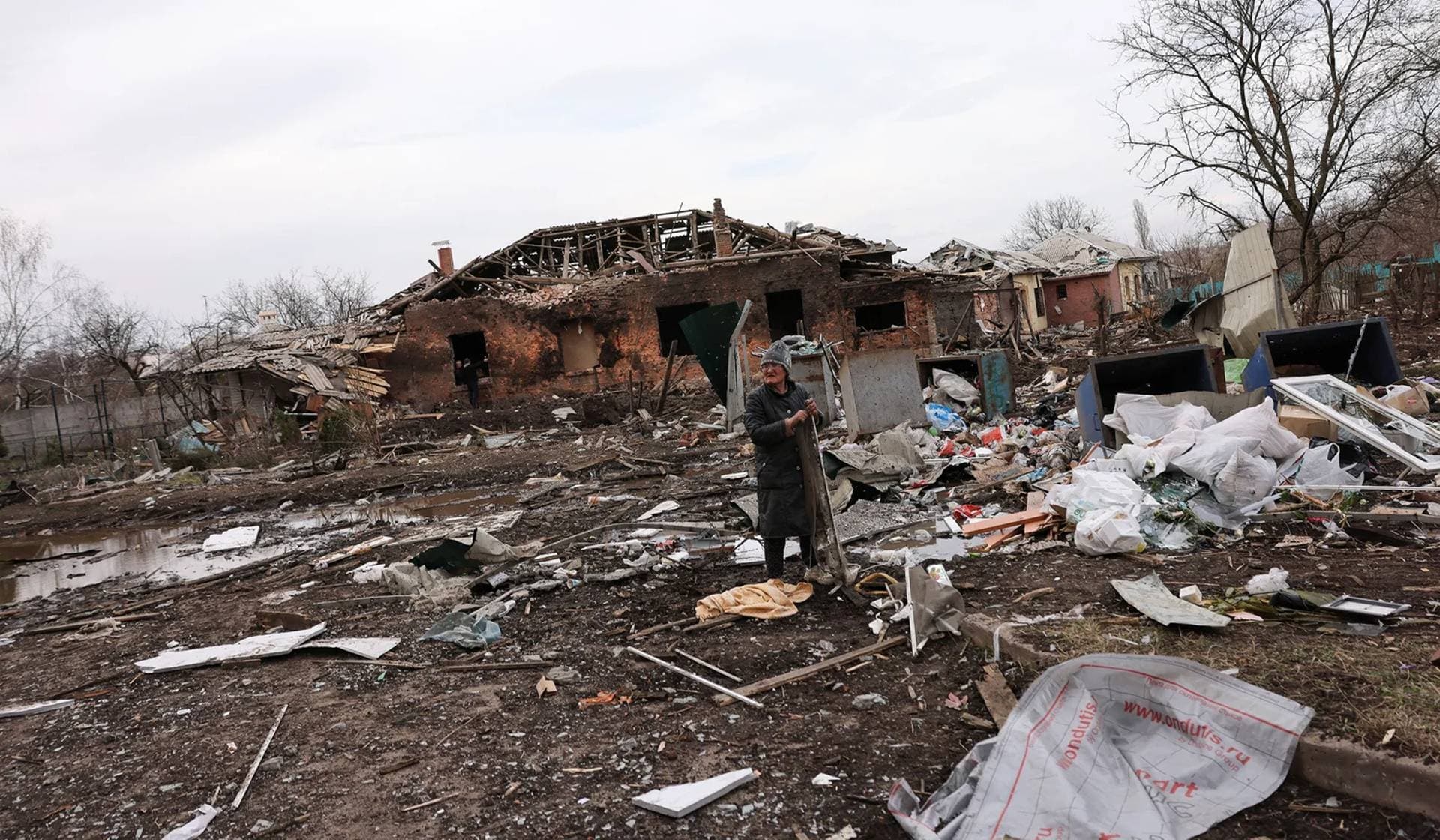 A person collects scrap metal in the aftermath of deadly shelling of residential buildings in Kostiantynivka
