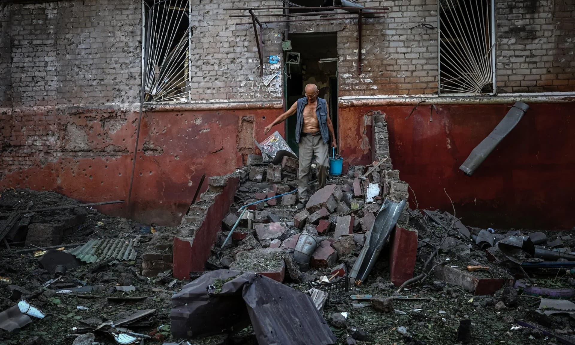 A man leaves his damaged apartment building following a missile strike in Kramatorsk