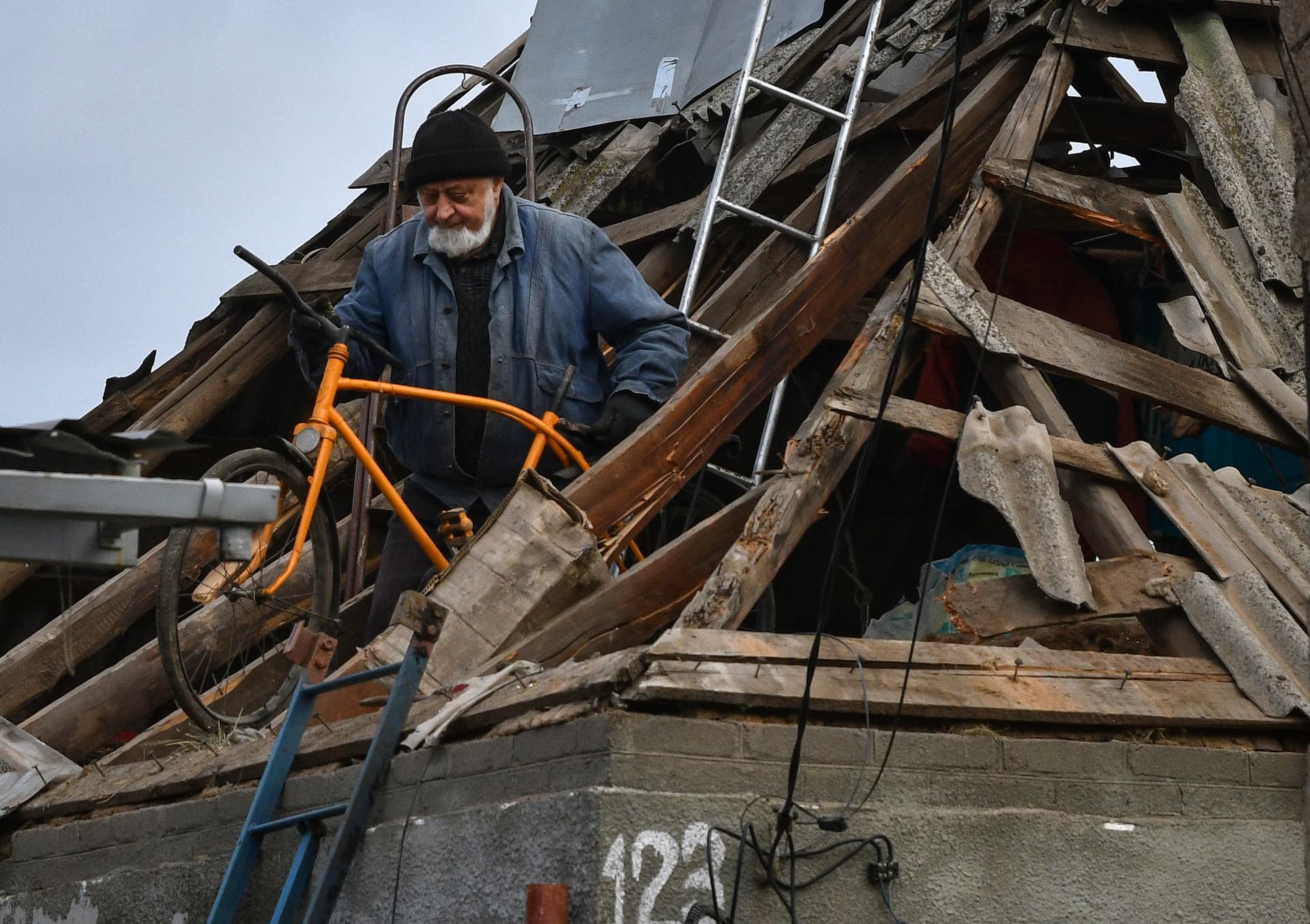 A local resident moves a bicycle from the attic of damaged house after Russian shelling in Kramatorsk