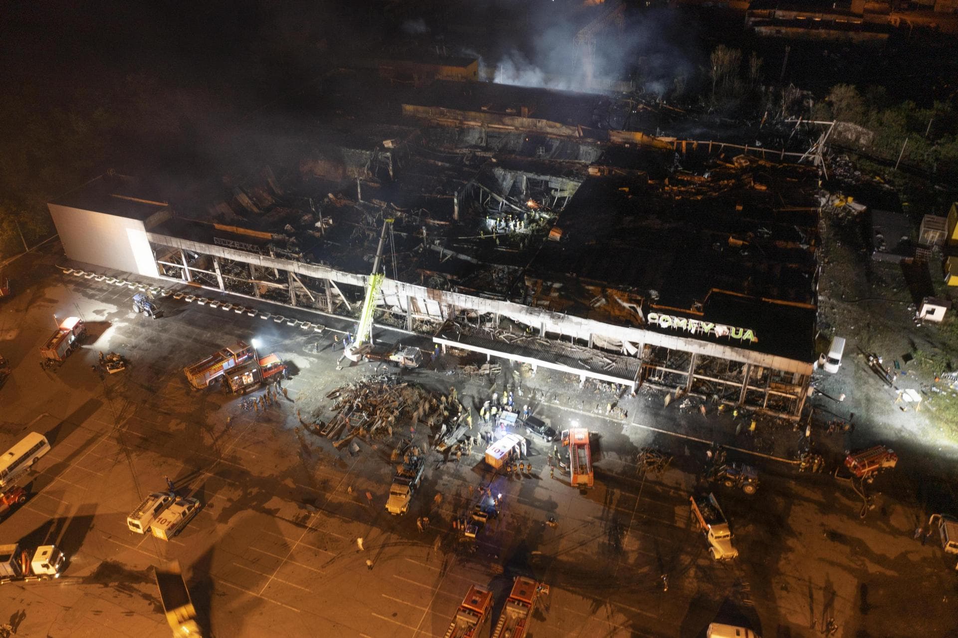Ukrainian State Emergency Service firefighters work to extinguish a fire at a shopping center burned after a rocket attack in Kremenchuk