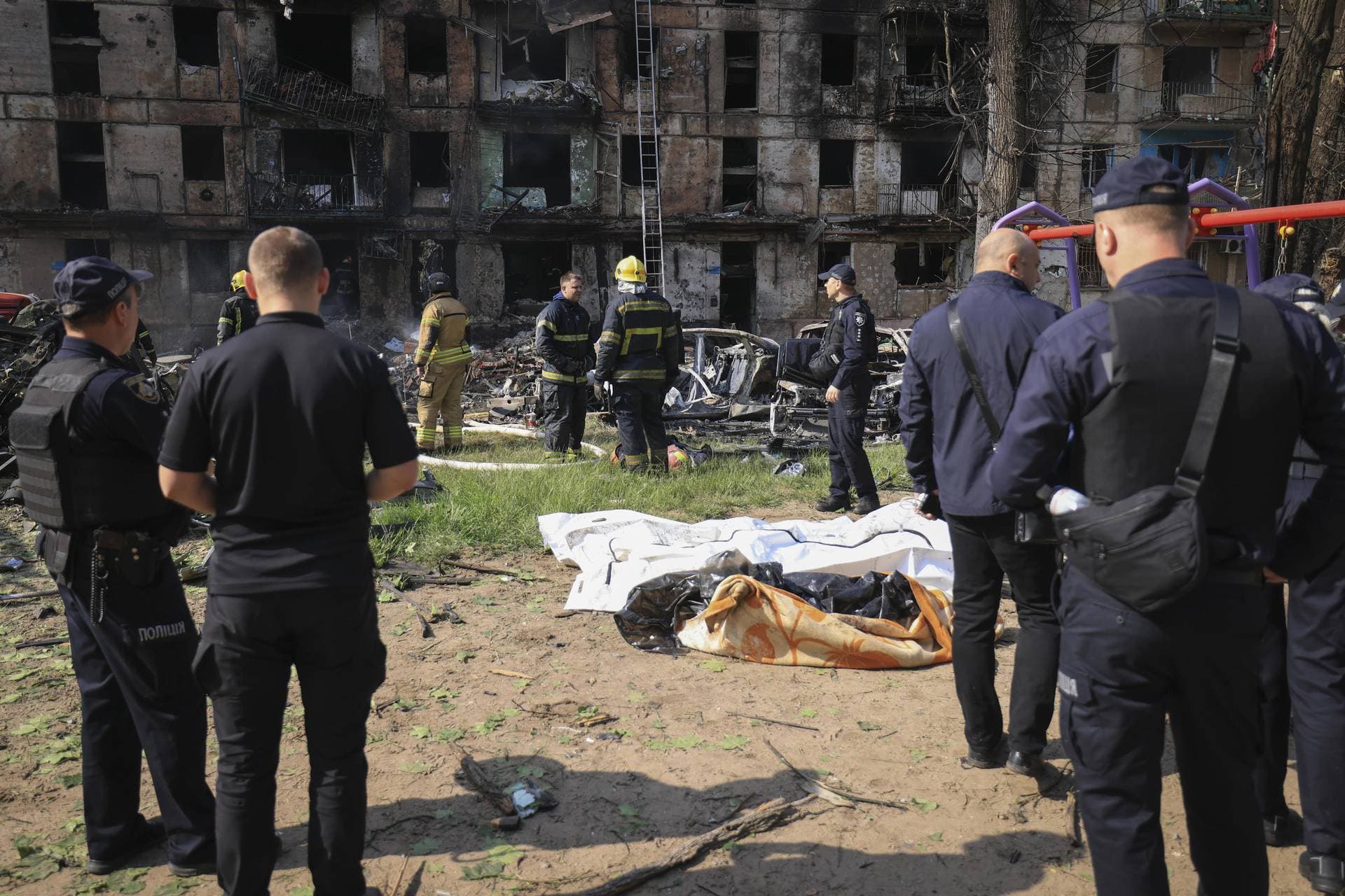 Police stand by dead bodies at the scene of damaged multi-storey apartment building caused by the latest rocket Russian attack in Kryvyi Rih