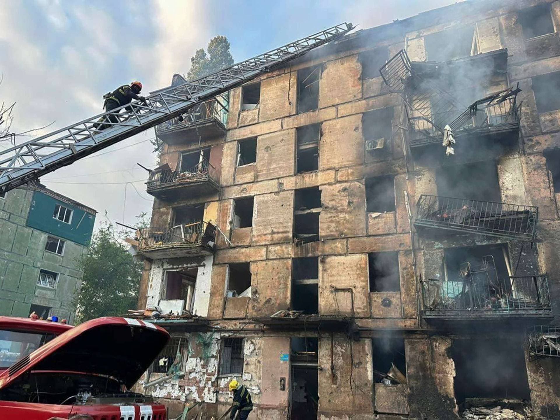 In this photo released by Dnipro Regional Administration, emergency workers extinguish a fire after missiles hit a multi-story apartment building in Kryvyi Rih