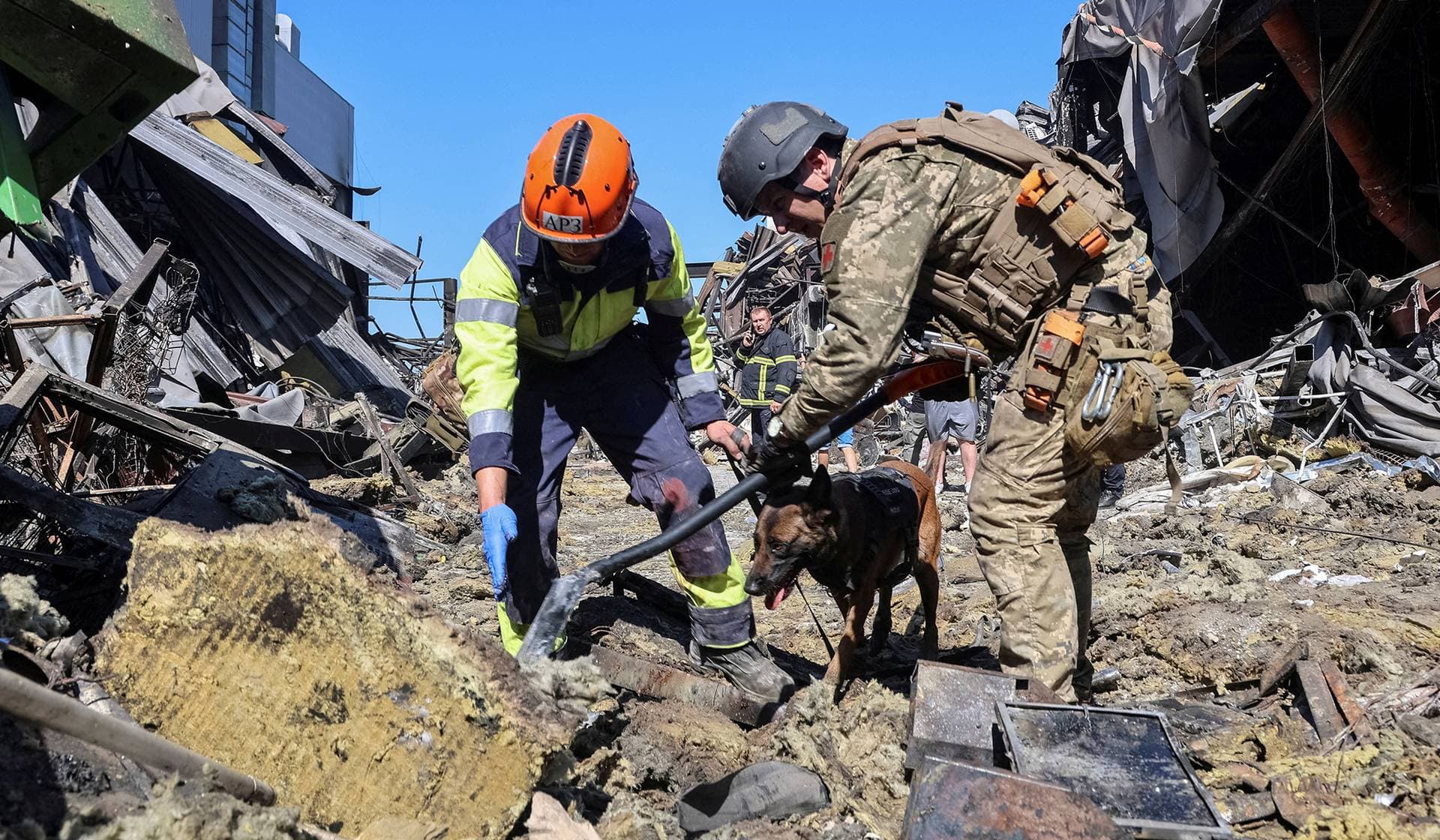 Rescuers with a dog work at a site of a shopping centre destroyed by yesterday's Russian drone attack in the city of Kryvyi Rih