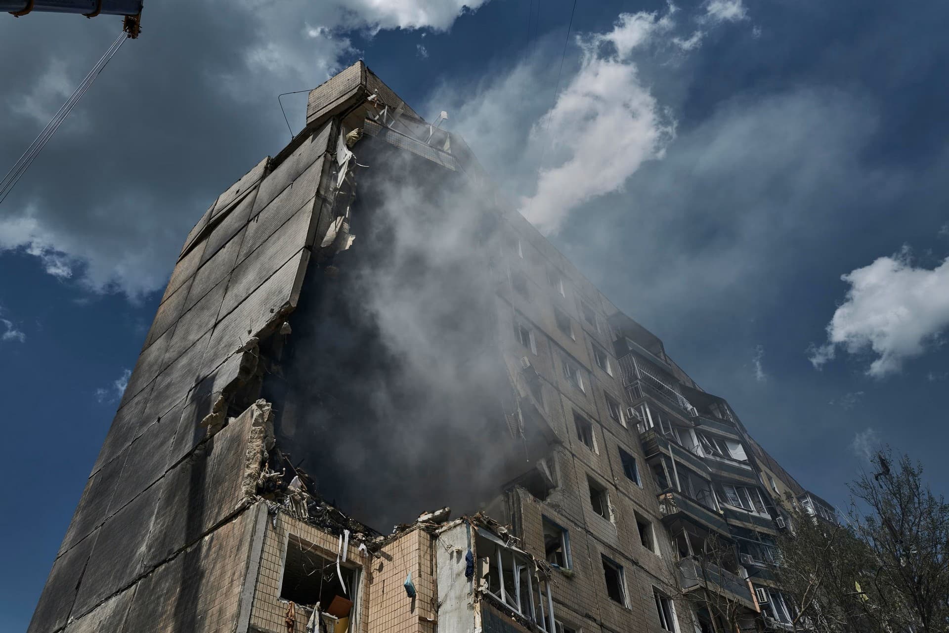Emergency services work at an apartment building after a missile strike in Kryvyi Rih