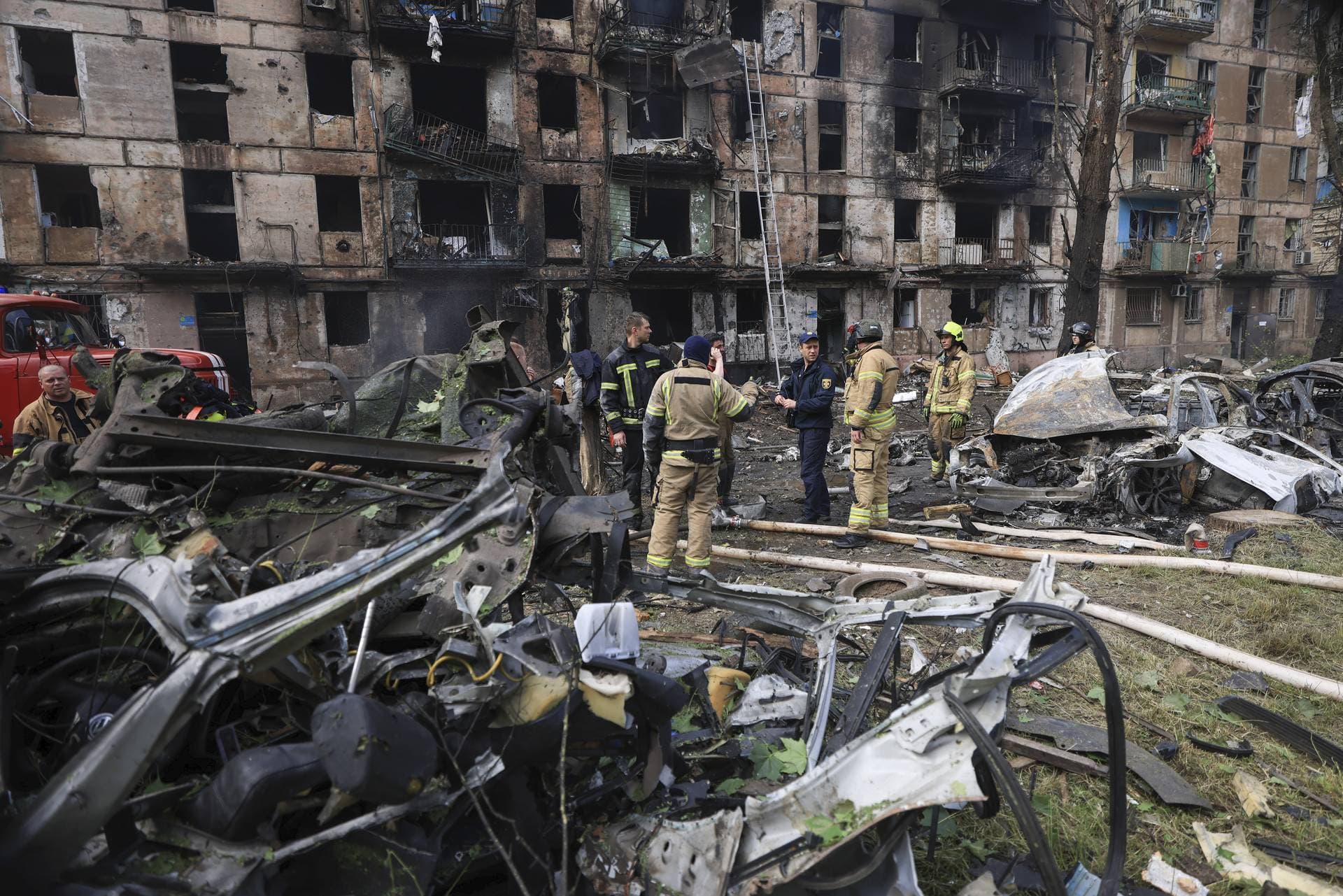 Emergency workers inspect a damaged multi-storey apartment building caused by the latest rocket Russian attack in Kryvyi Rih
