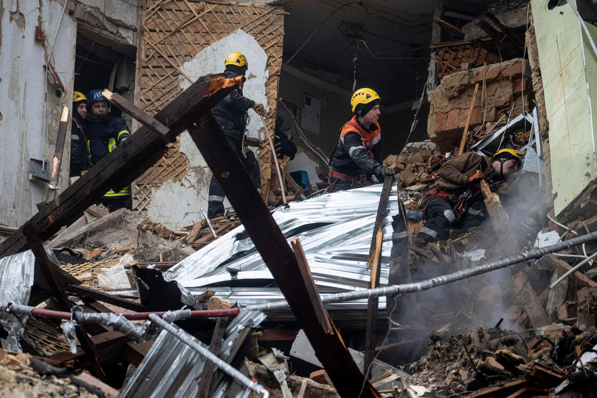 Ukrainian State Emergency Service firefighters work at the building which was destroyed by a Russian attack in Kryvyi Rih