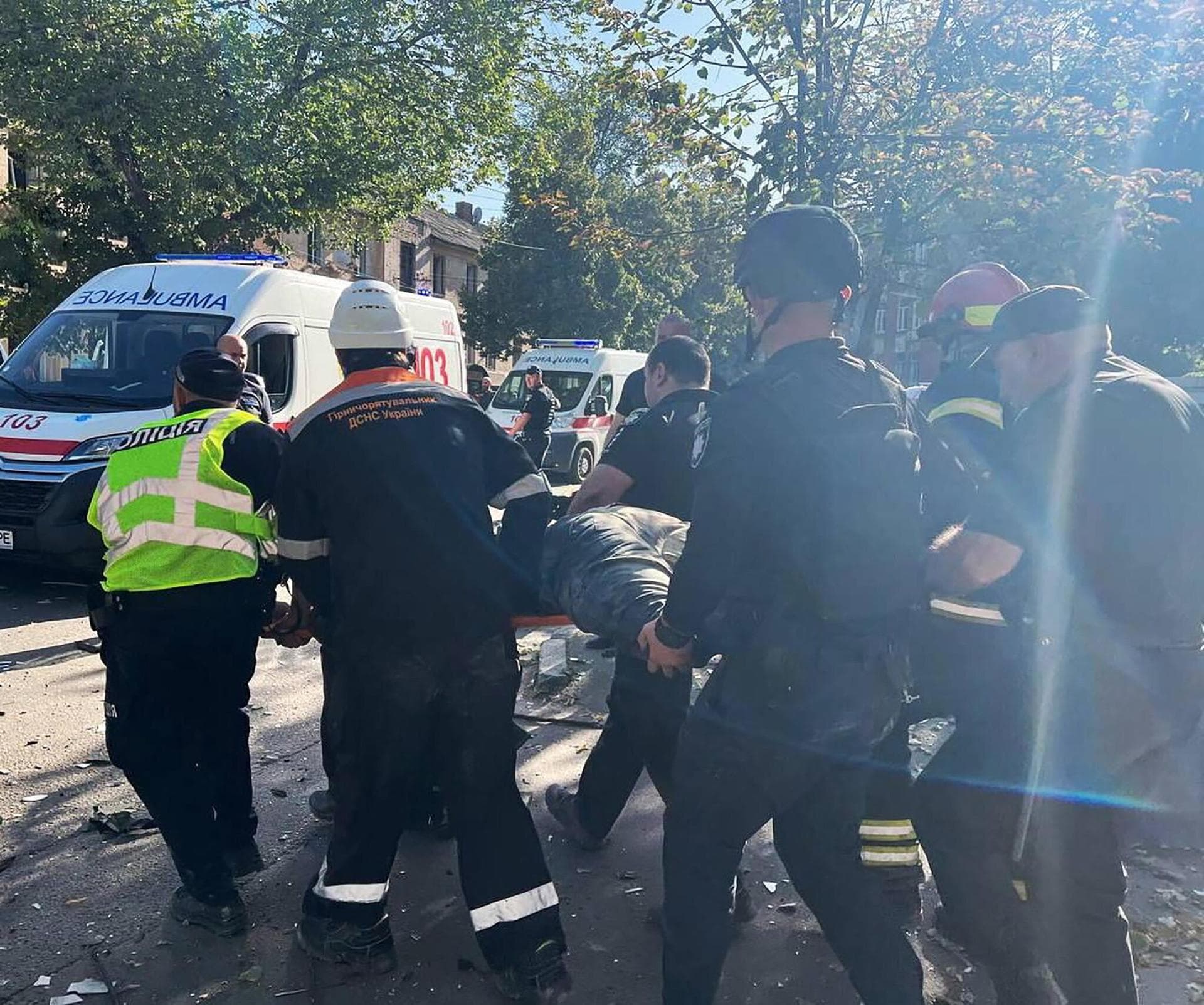 Rescuers and police officers carry a person released from debris at a site of a Russian missile strike in Kryvyi Rih