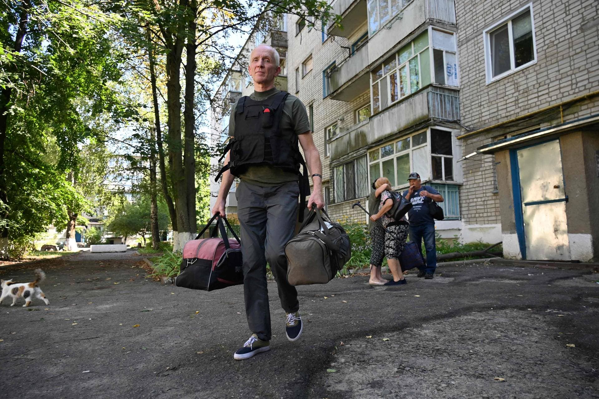 A volunteer helps local residents to evacuate from Kruglyakivka village, near Kupiansk