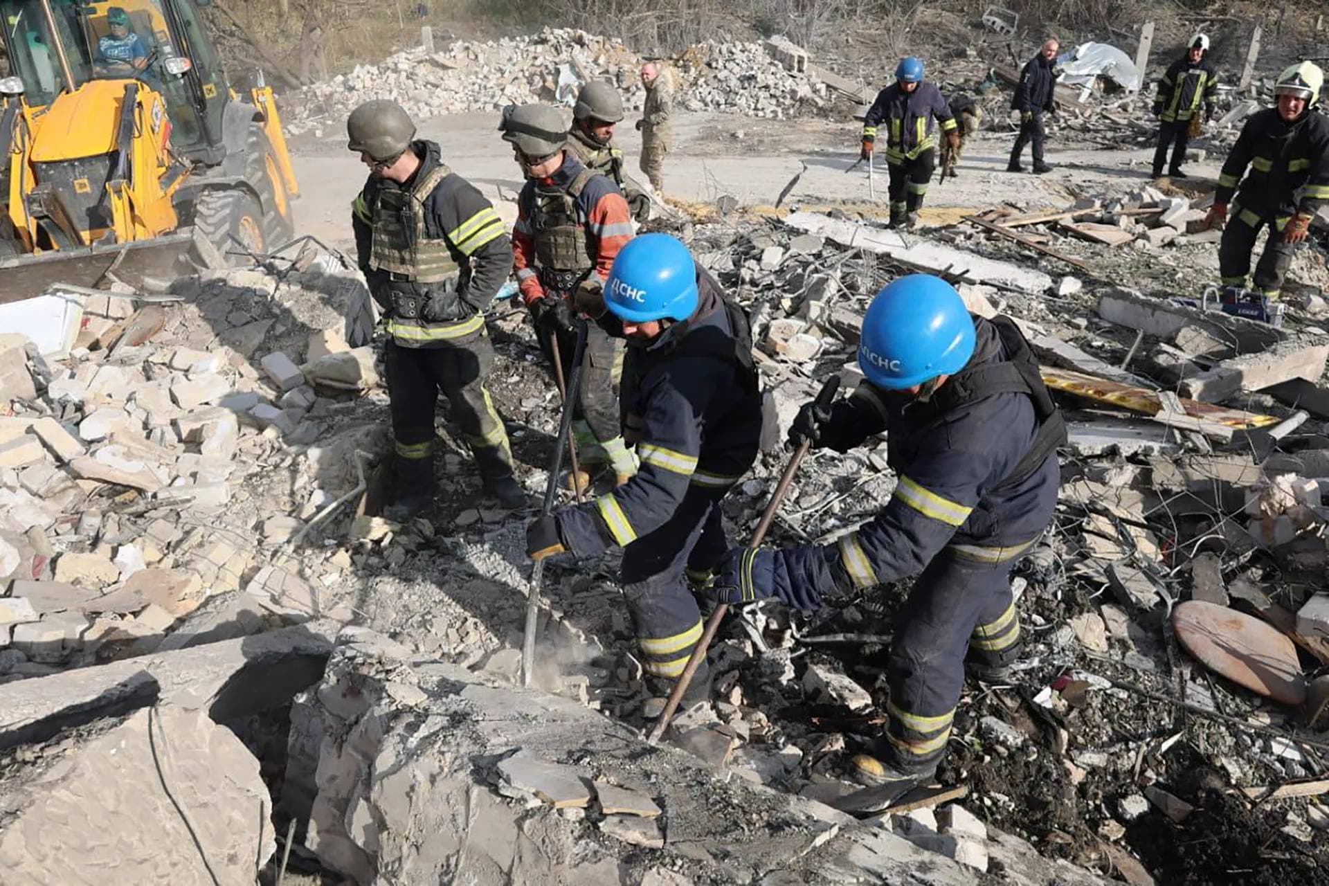 Emergency workers search for the victims of the deadly Russian rocket attack in the village of Hroza