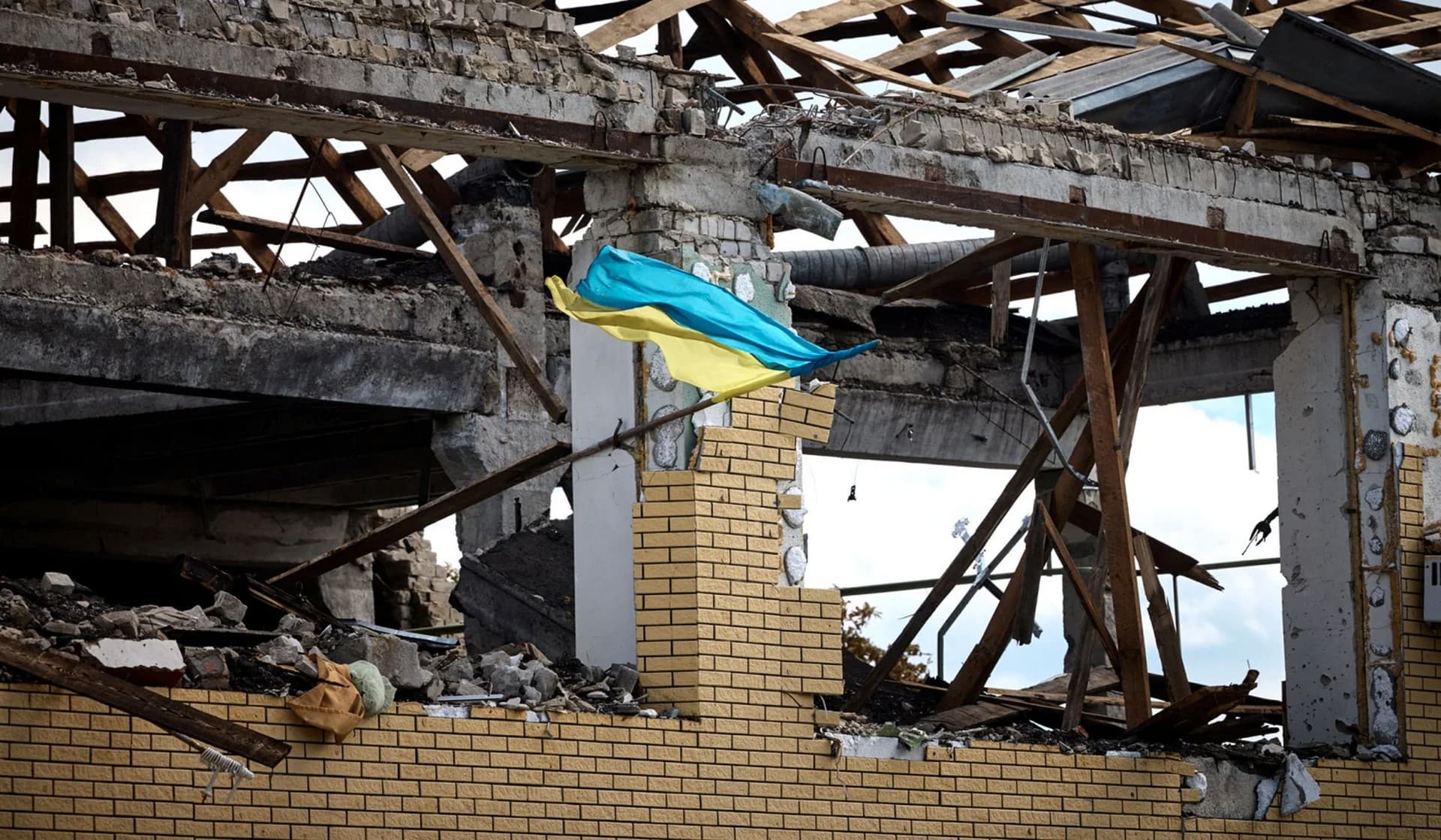 A Ukrainian national flag flutters on a damaged building in the town of Kupiansk
