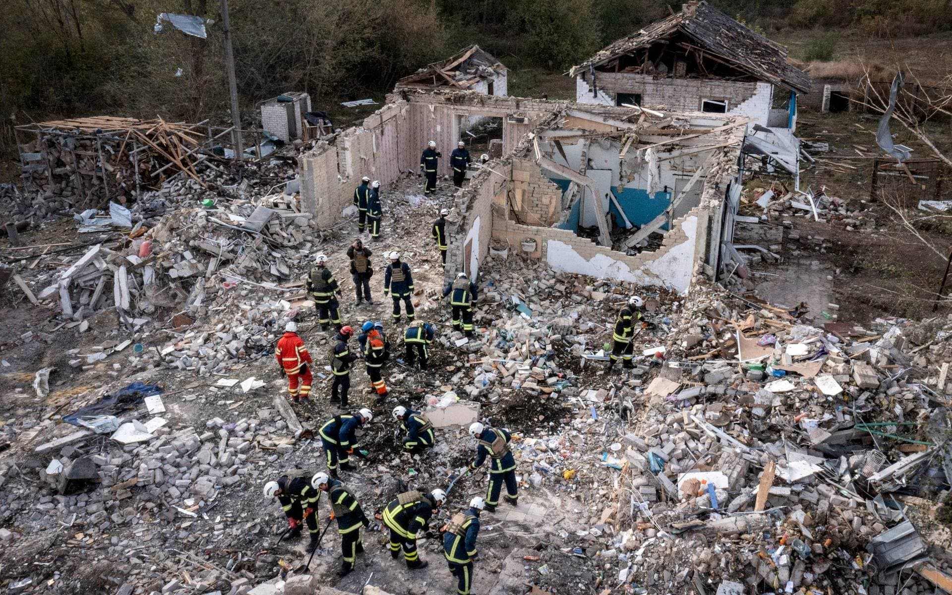 Rescue workers dig through the rubble at the site of a missile attack on the village of Hroza