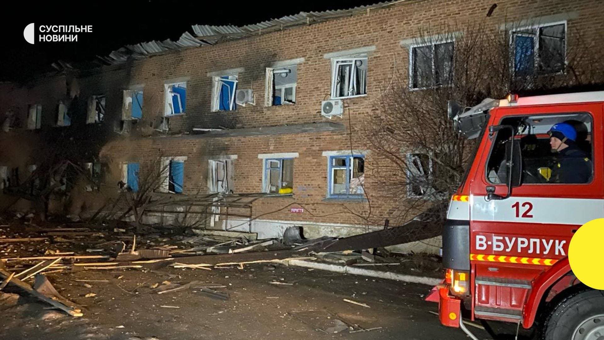 a fire truck next to a building damaged following a bomb blast at a hospital in Velykiy Burluk