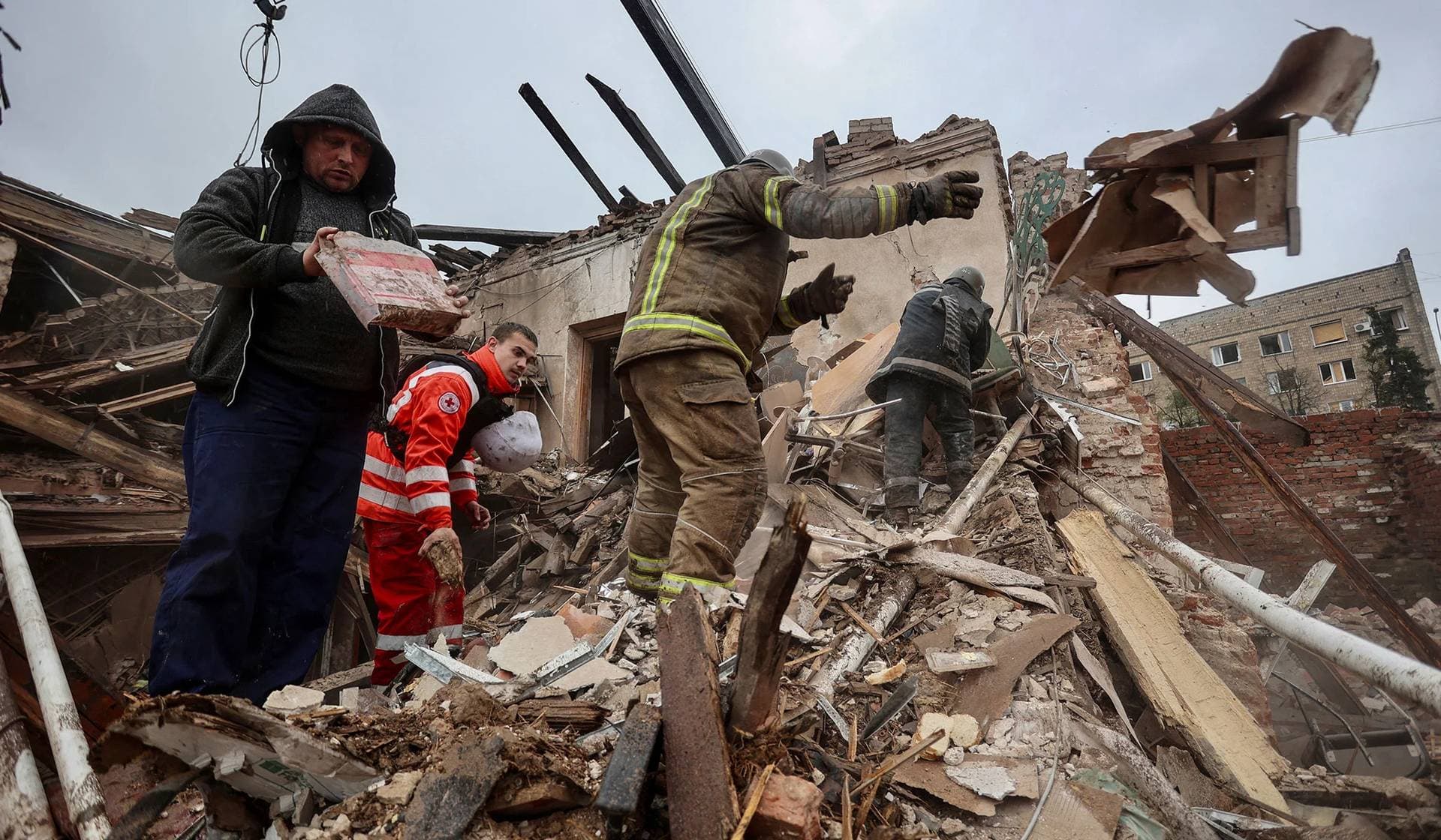 Rescuers and volunteers work at the site of a building of local museum heavily damaged by a Russian missile strike in Kupiansk