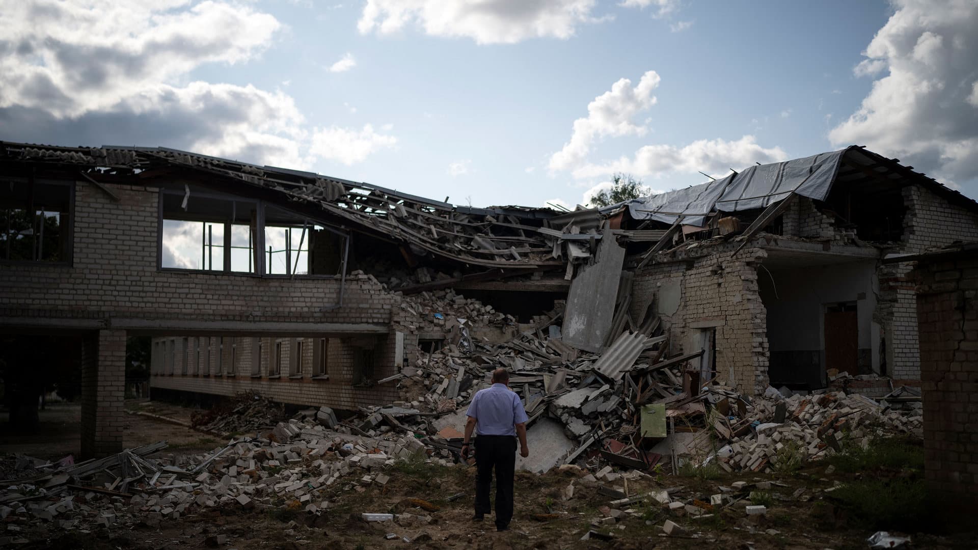 Oleksandr Pishchyk, a school director, stands in front of the school library that was destroyed by shelling in Kupiansk