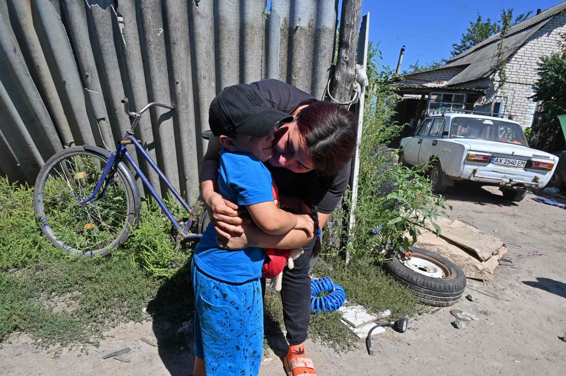 Lilia Bunescu says goodbye to her son, who is going to be evacuated from Kruglyakivka village, near Kupiansk