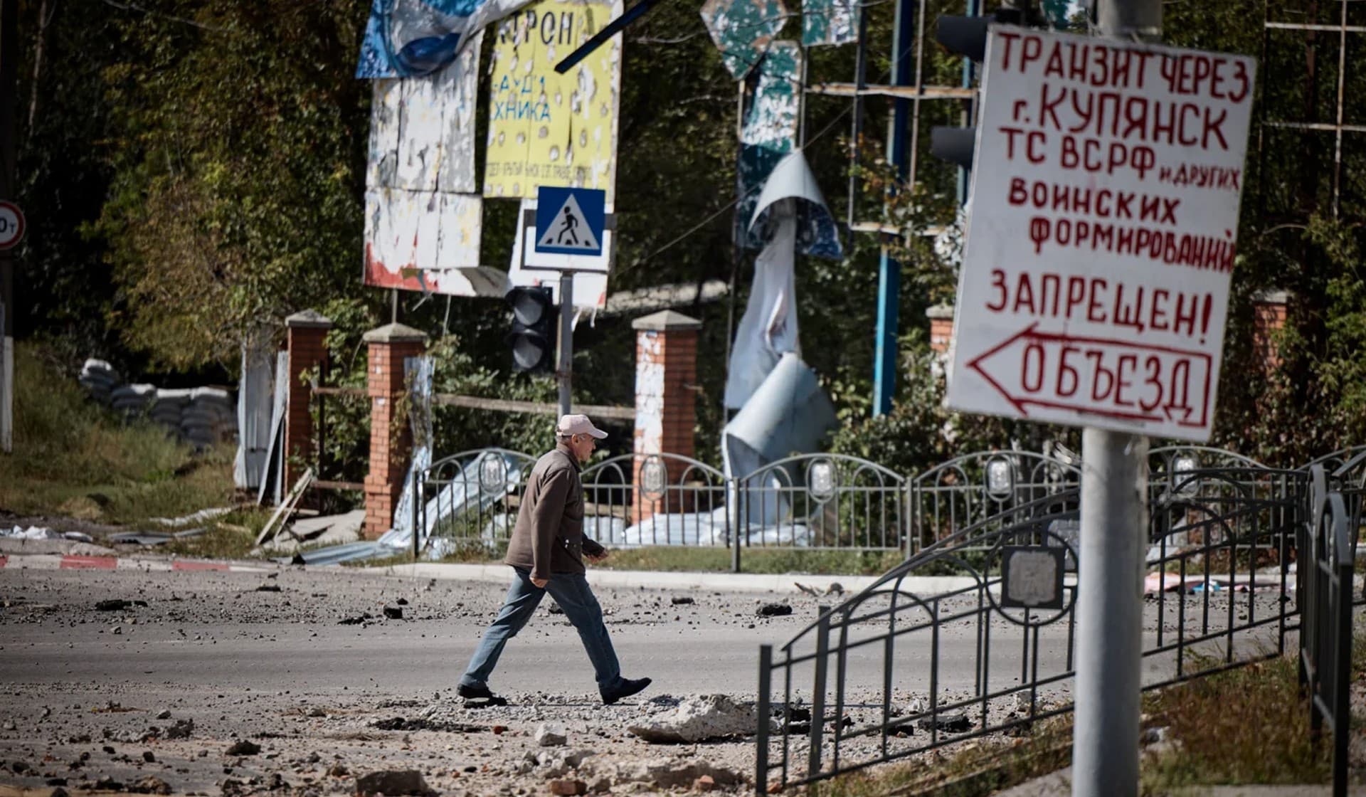 A man walks along a damaged street in the town of Kupiansk