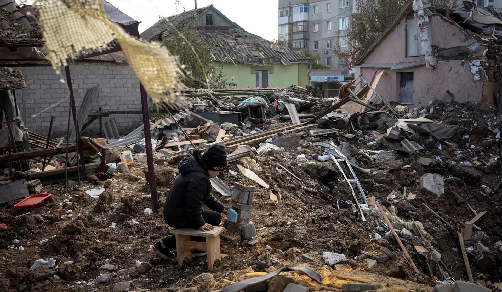 A boy plays on ruins of his grandmother's house in Kupiansk