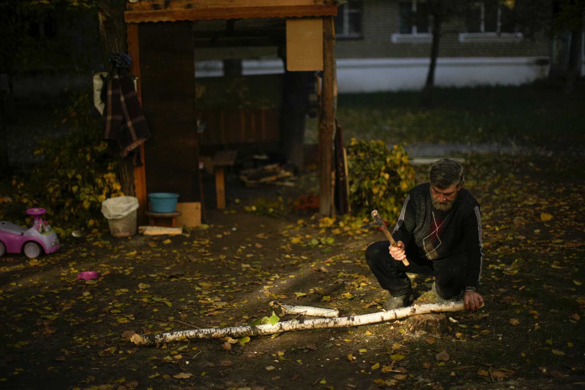 A local man cuts pieces of firewood in Kivsharivka