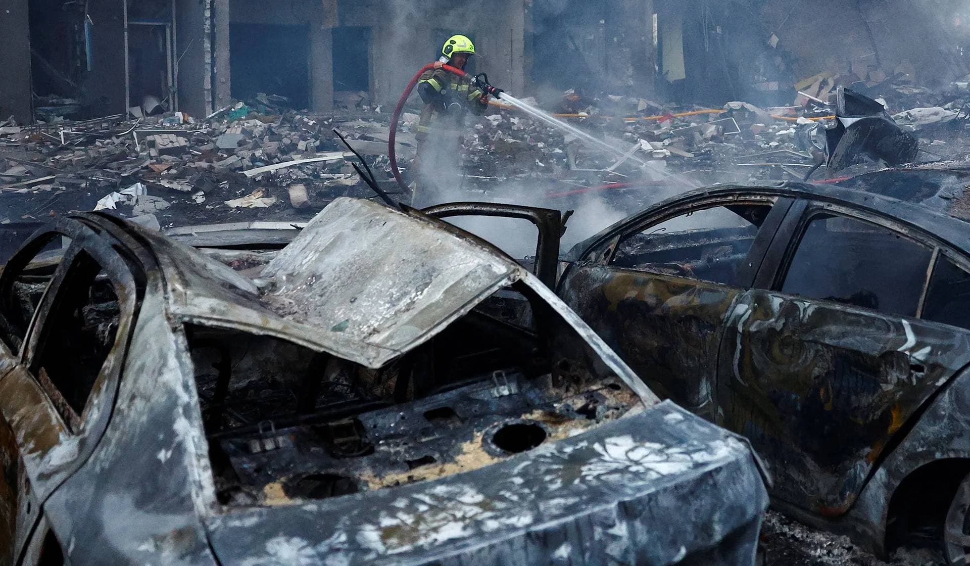 A firefighter works at the site of an apartment building heavily damaged during Russian missile and drone strikes in Kyiv