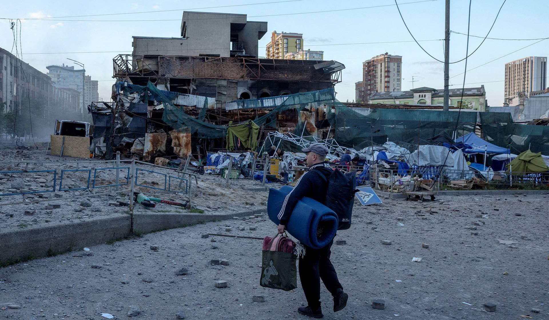 A man inspects the damage after leaving a metro station where he sheltered during a night of Russian missile strikes in Kyiv