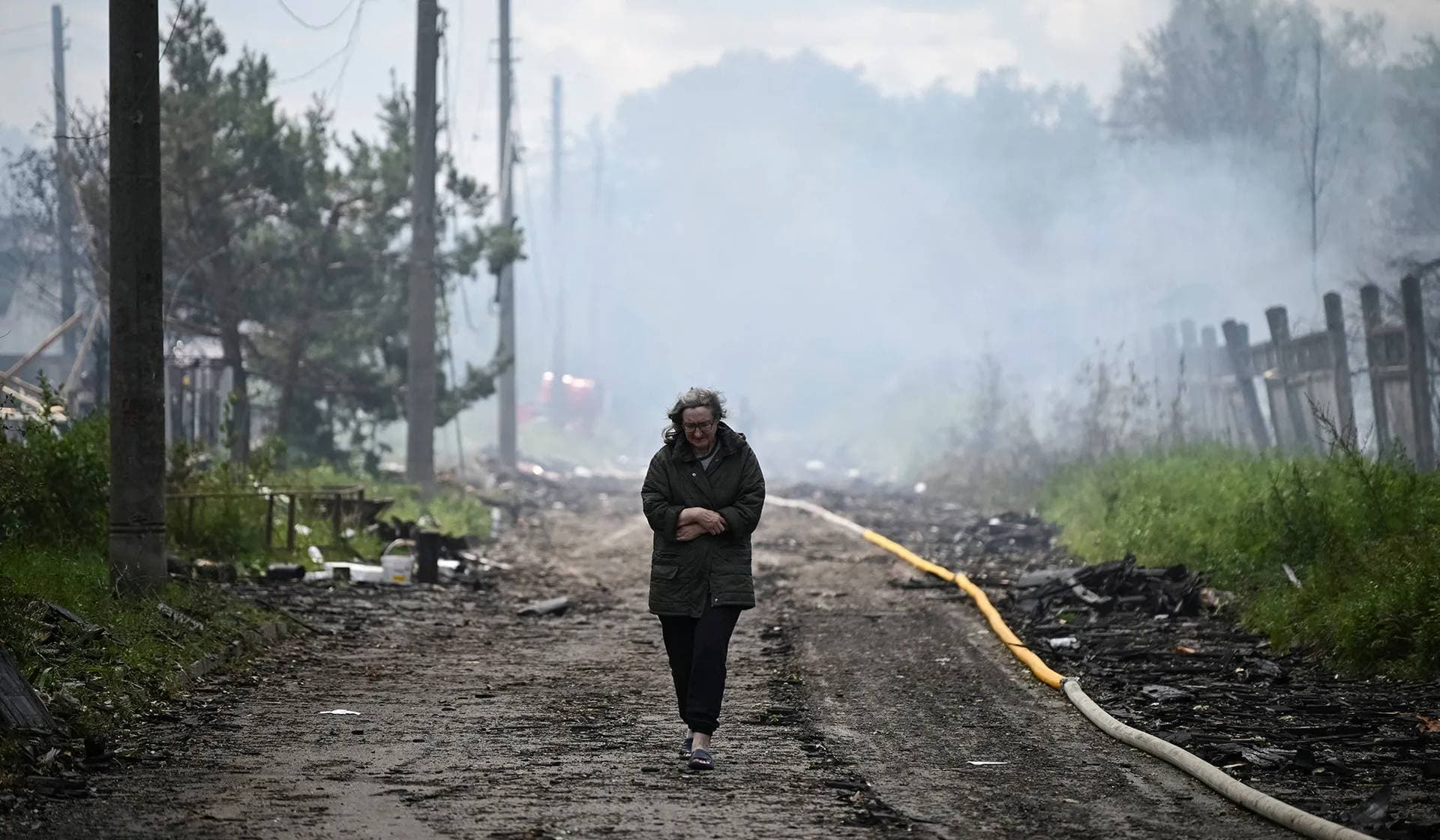 A resident walks on a street at a site of a Russian missile and drone strikes on the outskirts of Kyiv