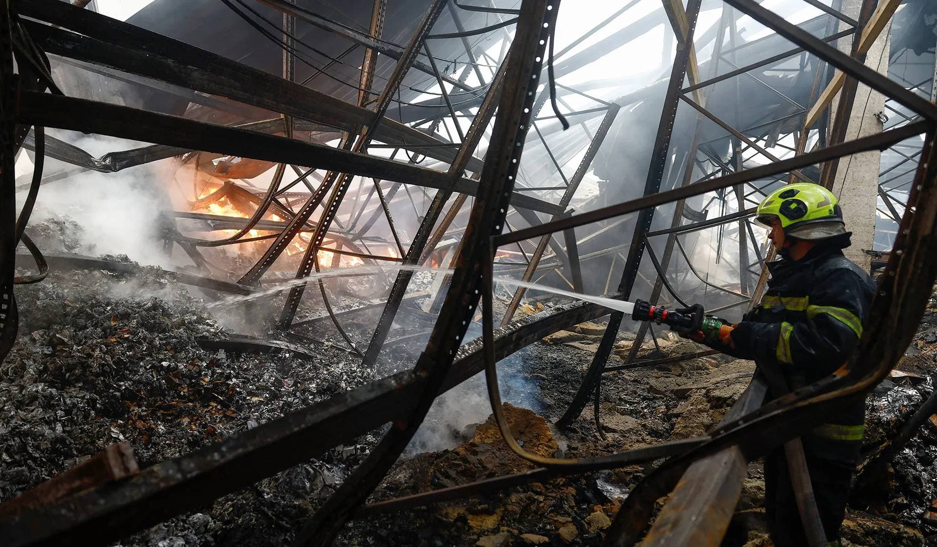 A firefighter works at the site of food and drink warehouses hit by an overnight Russian missile strike in Kyiv, Ukraine, July 8, 2026.