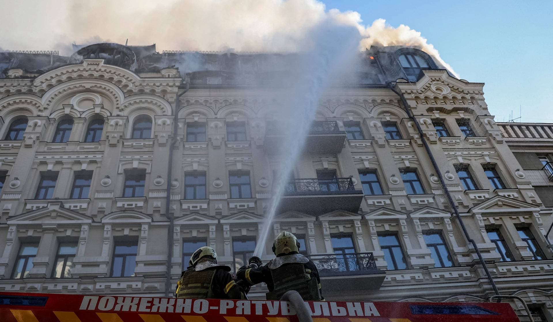 Firefighters work at the site of a hotel building damaged during a Russian missile and drone strike in Kyiv