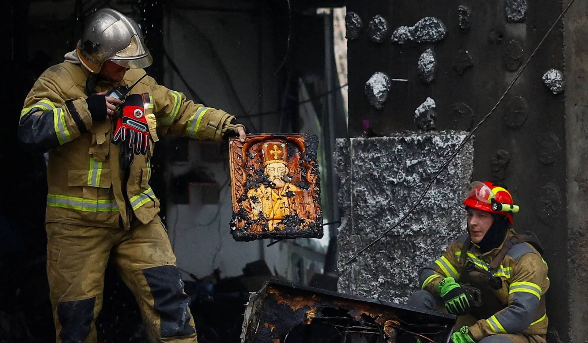 A rescuer holds an Orthodox Christian icon found amid the debris at the site of an apartment building heavily damaged during Russian missile and drone strikes in Kyiv